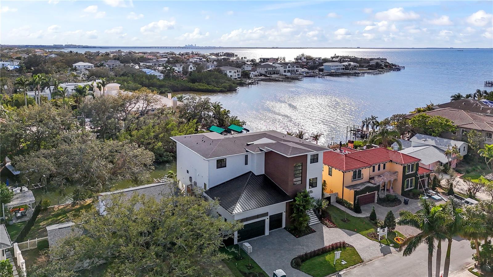 WATERFRONT NEW CONSTRUCTION that is MOVE IN READY!! The floorplan offers 6,078 sf of air-conditioned living space that includes 5 Bedrooms, 6.5 baths, + den/study constructed in the Coastal Contemporary Style with multiple covered outdoor areas and incredible open water views. The car enthusiast will appreciate the 7+ car garage plus a ton of space for storage that is perfect for all your pool and boating toys. Out back is the 38ft long pool with spa & cold plunge! Overlooking the pool is a huge ground floor Cabana plus a beautiful 2nd floor lanai located off the kitchen featuring an outdoor kitchen, pool bath, and an al fresco dining area offering majestic water views. The property is turn-key with a new seawall and new 32x10ft dock with composite decking and a 10,000 lb boat lift. Step through the 10ft wood and glass front door onto wide plank wood floors, 7 3/4" baseboards, crown molding, 12ft ceilings, and an enormous Great Room with a stunning wall of windows offering beautiful views of mangroves and open water. The gourmet cook will appreciate this top-of-the-line kitchen which features natural stone counters, a large island with a 5ft Galley Brand sink, Subzero fridge, gas Wolf range, and Cove double dishwasher, ice maker, and huge butler's pantry and additional walk-in pantry. This luxury home has extras galore including: ELEVATOR with 3 stops, primary bedroom with his and her water closets, 8ft solid core interior doors, electric charging ports in the garages, reverse osmosis water system by Kinetico, gas tankless water heaters, pre wiring for security cameras, sound-proof flooring and insulation between all rooms, 6 internet access points (WAP), laundry room with 2 sets of washers and dryers, custom closets systems in all rooms, +++. A truly magnificent home!