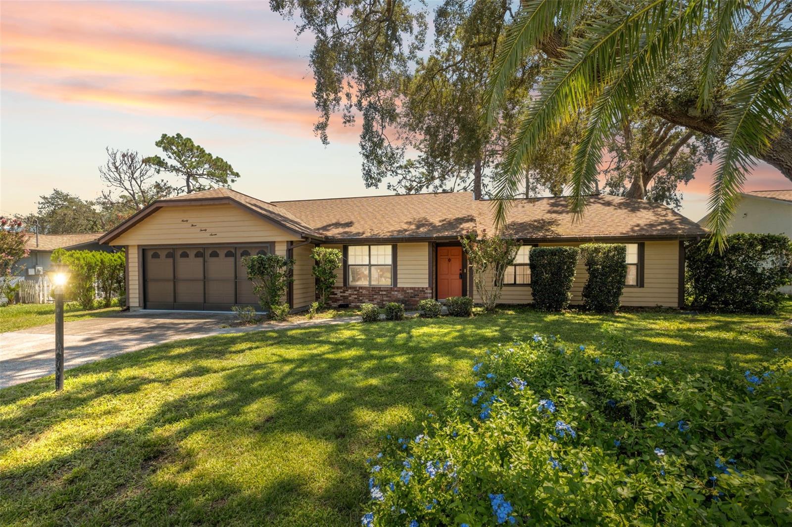 Under contract-accepting backup offers. Step inside this charming two-bedroom, two-bath home with a two-car garage and feel instantly welcomed by its thoughtful layout and inviting character, from the covered entry framed by mature trees and landscaped yard that evoke an Old Florida feel, to the foyer with its handy coat closet leading into a spacious living and dining room combination accented by bay windows that bathe the space in natural light. The split plan design offers privacy, with vinyl floors throughout most of the home and a dining area that flows seamlessly to a bright kitchen featuring granite counters, real wood cabinets, white appliances, closet pantry, tiled floors, and a cozy breakfast nook surrounded by bay windows. Just beyond, a versatile family room provides an additional gathering space and opens through a wall of sliding glass doors to a covered Florida room, perfect for enjoying the view of the oversized backyard with shade trees and plenty of space to add a pool, playground, or garden. The primary suite boasts a very large walk-in closet and a beautifully preserved retro-style ensuite bathroom with its original green fixtures and wood cabinetry, while the second bedroom includes dual closets and a second full bath featuring its own vibrant, well-maintained vintage design. The garage not only has built-in cabinets for storage but also sliding screen doors, allowing you to enjoy relaxing breezes while comfortably sitting in the space. Outside, the landscaped lot and mature trees enhance the feeling of a private retreat. Conveniently located just 2 miles from the Suncoast Expressway, commuting to Tampa or exploring nearby Gulf Coast beaches is effortless, making travel both practical and enjoyable. Local attractions include Weeki Wachee Springs State Park, only 8 miles away, where crystal-clear waters and scenic kayaking abound; Hernando Beach, about 12 miles away, offering waterfront dining and boating access; and the Nature Coast Botanical Gardens, just 5 miles away, a peaceful spot for strolling through themed gardens filled with native plants and flowers.