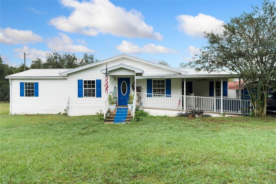 This double-wide mobile home is situated on a sprawling 1.01 acres of beautifully cleared land, offering a serene and spacious living environment. The property features a convenient carport, complete with a ramp leading up to the front door, all seamlessly connected under a single structure that includes a small front porch and an inviting awning at the entrance.

Inside, the home boasts three bedrooms and two bathrooms, designed to accommodate both comfort and functionality. The master bedroom is a true retreat, featuring an en-suite master bathroom equipped with his-and-hers sinks, a luxurious soaking tub, and a spacious walk-in shower. Bedroom 2 is enhanced by a walk-in closet, while Bedroom 3 offers a built-in closet. These rooms share the second bathroom, which is fitted with a practical shower-tub combination.

The living spaces are defined by an open floor concept, seamlessly connecting the living room and dining area with the family room located near the entrance. The kitchen is a focal point of the home, featuring a breakfast bar and two serving windows that add to its functionality and charm. Natural light floods the space through the numerous windows, offering stunning views of the surrounding property.

The back of the home opens up to a covered porch, leading to a dedicated dog run, perfect for pet owners. Additionally, there's a garage located behind the carport, providing ample space for additional parking tools and equipment. The entire property is fenced, ensuring privacy and security.

Notably, this property is free from the constraints of Homeowners Association (HOA) or Community Development District (CDD) fees, adding to its appeal for those seeking a peaceful and unrestricted living experience.