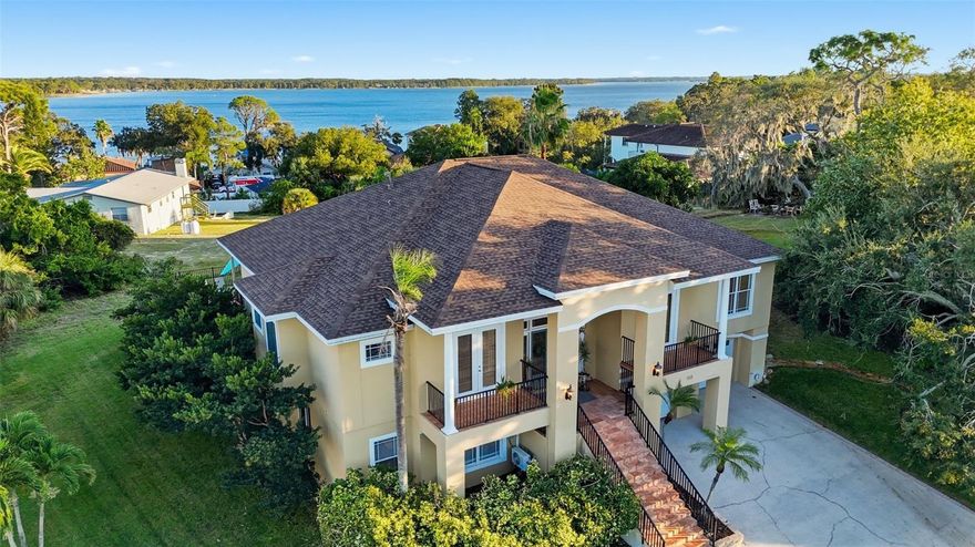 Enjoy breathtaking views of Lake Tarpon from this large custom home, perfectly positioned on one of the most elevated lots in the area. This stunning 4 bedroom + den, 4 bathroom, 4,200sqft home sits directly behind a protected gopher tortoise reserve, ensuring that nothing will ever be built behind you — your serene water views are forever preserved.
Nestled in Waterberry, an intimate, highly sought-after community of only 14 homes on Lake Tarpon, this is one of only a handful of homes that have ever come to market, with only one sale in the past two years. Homes here rarely change hands, making this a rare opportunity to own in one of Tarpon Springs’ most exclusive neighborhoods. Built on a massive hill, high above the floodplain and well beyond Flood Zone X, this home is completely high and dry — it sustained absolutely no storm damage and requires no flood insurance.
Inside, you find plenty of space for the entire family with all four bedrooms featuring ensuite bathrooms! On the main level, you’ll immediately notice the stunning hardwood floors, open-concept layout, high coffered ceilings and water views from nearly every room. The primary suite and main level showcase real hardwood floors, tray ceilings, and elegant finishes throughout. The living room features a beautiful fireplace, crown moldings, and fantastic views of Lake Tarpon. Just off the living room is the kitchen, complete with wood cabinetry, granite countertops, newer stainless steel KitchenAid appliances, and a spacious eat-in area perfect for breakfast. The formal dining room off the kitchen is ideal for larger gatherings and celebrations. On the opposite side of the living room, French doors open to a versatile den, perfect for a home office with its own private balcony. The lower level (or basement) has been fully permitted and thoughtfully finished to include over 1,300sqft of living space, including a private 4th bedroom or in-law suite, a game room, plus plumbing for a wet bar or kitchen — ideal for guests, multi-generational living, or entertaining. You’ll also find a dedicated wine cellar for your collection.
Relax in style on your large covered porch overlooking the pool and lake. Step outside to your private paradise and enjoy a resort-style saltwater pool with water features, firepit, and a raised patio perfect for nighttime entertaining — all while taking in tranquil water views of Lake Tarpon from the pool deck. The 0.28-acre (12,589 sq ft) lot offers generous outdoor space and an oversized 4-car garage with plenty of room for a boat or extra storage.
Recent upgrades provide complete peace of mind and modern comfort, including a new roof (2022), a new central HVAC system (2022), with a new mini-split for the lower level added in 2023, and remodeled primary bathroom and remodeled guest bathrooms (2023). This home features a new hot-water heater (2022), electronic and manual roller shades throughout (2022), and a newer Maytag washer and dryer (2020). A propane tank added in 2021 provides convenient gas service with easy, once-a-year fill-ups.
Aggressively priced below comparable homes, this Lake Tarpon gem combines serenity, luxury updates, and unmatched elevation — all with no flood insurance required, low HOA costs, and no CDD fees.