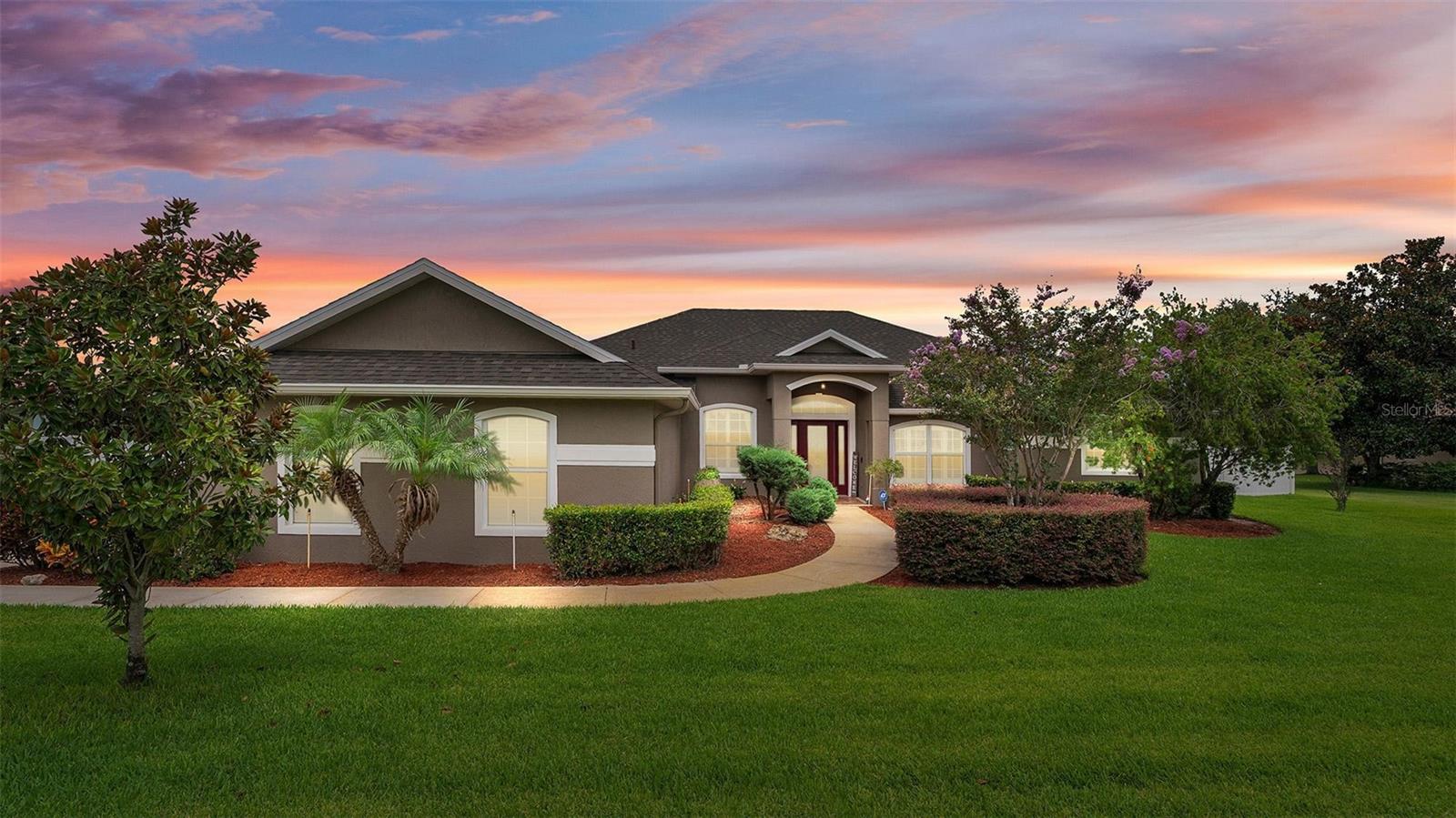 Welcome to 13031 Colonnade Circle located in the rolling Hills of Clermont, Florida.
This thoughtfully designed floor plan is functional and comforting for any growing family. As you walk through the front door, you'll be greeted by tall, vaulted ceilings, a formal dining room to your left and the formal living room to your right. Soaring sliding glass doors that lead you out onto the enclosed back patio that has been extended and fully screen enclosed. The home sits on nearly half an acre of lush green grass, surrounded by some light landscaping, a few flowering trees and is fully fenced. Heading back inside, the home features a sizable kitchen with an abundant amount of counter space, stainless steel appliances, tile backsplash, built-in wine rack, bar seating, double door pantry, and a breakfast nook. Connected to the kitchen is a comfortable family room and off the family room down the hall are two bedrooms that share a bathroom with a shower tub combo perfect for the littles and on the far side is a separate bedroom with an ensuite bathroom that has a tile standalone shower. Get excited to come home to your private primary suite on the south end of the home. This room brings in an abundance of natural lighting with views of the patio and backyard through the sliding glass doors. The primary bath is equipped with dual walk-in closets, dual vanities, a soaking tub, and a standalone shower. Off the primary suite is your very own home office with large windows and double doors. Whether you’re investing or nesting, this home has everything you could ever need. Private well for irrigation, that won’t run up your water bill, a brand-new roof put on in 2025, upgraded shutter window treatments, rain gutters, a three-car garage and ample driveway parking in an established low HOA community. Conveniently located in the heart of Clermont. Call to schedule your appointment today.
