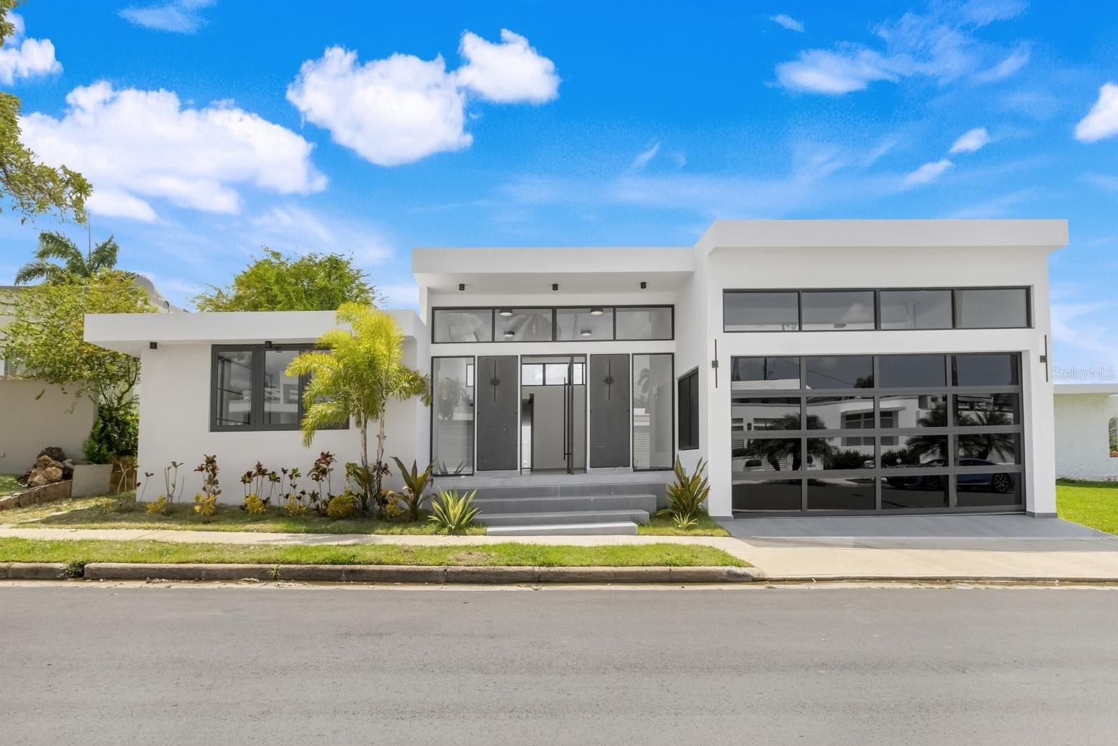 Discover the elegance of a thoughtfully reimagined contemporary home in the heart of Torrimar, one of Guaynabo’s well-connected neighborhoods. This exquisitely expanded and fully remodeled residence offers 3,502 square feet of meticulously designed living space on a 600-square-meter lot, blending refined architectural elements with modern comfort and functionality.
The home features four generously sized bedrooms and three and a half bathrooms, perfectly suited for both everyday living and upscale entertaining. A spacious open-concept layout seamlessly connects the living, dining, and kitchen areas, creating a warm and inviting atmosphere for family life and social gatherings alike. The chef’s kitchen showcases premium finishes, including Calacatta Michelangelo stone countertops and a custom wine cellar—ideal for culinary enthusiasts and hosts. The expanded primary suite includes a completely redesigned walk-in closet and a beautifully updated en-suite bathroom, offering a serene and private retreat.
Additional highlights include an inviting terrace and a private pool—perfect for relaxing or entertaining guests in style. New air conditioning systems and expansive floor-to-ceiling windows bathe the interior in natural light while providing year-round comfort. A garage and carport a practical convenience for multiple vehicles. Located within a secure, family- oriented gated community, the property offers privacy, peace of mind, and an exceptional residential setting.
Ideally positioned for both convenience and lifestyle, this home is just minutes from top-rated schools, leading medical centers and hospitals, pharmacies, and wellness services. Residents enjoy immediate access to the Torrimar Tren Urbano station, major supermarkets, boutique convenience stores, and premier shopping and dining destinations such as San Patricio Plaza and GalerÃa San Patricio. The surrounding area also offers a wide variety of fine dining establishments, cafés, fitness centers, and sports facilities. For those seeking an elevated social and recreational lifestyle, the property is just minutes from the exclusive Caparra Country Club, which features tennis, beach tennis, pickleball, swimming, gourmet dining, and a full calendar of family-friendly events.
Whether you are a growing family or a professional in search of a sanctuary, 13-12 Santander Streetpresents a rare opportunity to live in style, comfort, and unparalleled convenience in one of Puerto Rico’s most desirable communities.