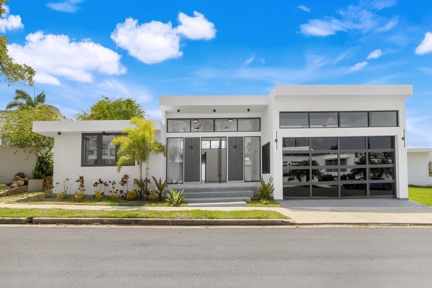 Discover the elegance of a thoughtfully reimagined contemporary home in the heart of Torrimar, one of Guaynabo’s well-connected neighborhoods. This exquisitely expanded and fully remodeled residence offers 3,502 square feet of meticulously designed living space on a 600-square-meter lot, blending refined architectural elements with modern comfort and functionality.

The home features four generously sized bedrooms and three and a half bathrooms, perfectly suited for both everyday living and upscale entertaining. A spacious open-concept layout seamlessly connects the living, dining, and kitchen areas, creating a warm and inviting atmosphere for family life and social gatherings alike. The chef’s kitchen showcases premium finishes, including Calacatta Michelangelo stone countertops and a custom wine cellar—ideal for culinary enthusiasts and hosts. The expanded primary suite includes a completely redesigned walk-in closet and a beautifully updated en-suite bathroom, offering a serene and private retreat.

Additional highlights include an inviting terrace and a private pool—perfect for relaxing or entertaining guests in style. New air conditioning systems and expansive floor-to-ceiling windows bathe the interior in natural light while providing year-round comfort. A garage and carport a practical convenience for multiple vehicles. Located within a secure, family- oriented gated community, the property offers privacy, peace of mind, and an exceptional residential setting.

Ideally positioned for both convenience and lifestyle, this home is just minutes from top-rated schools, leading medical centers and hospitals, pharmacies, and wellness services. Residents enjoy immediate access to the Torrimar Tren Urbano station, major supermarkets, boutique convenience stores, and premier shopping and dining destinations such as San Patricio Plaza and Galería San Patricio. The surrounding area also offers a wide variety of fine dining establishments, cafés, fitness centers, and sports facilities. For those seeking an elevated social and recreational lifestyle, the property is just minutes from the exclusive Caparra Country Club, which features tennis, beach tennis, pickleball, swimming, gourmet dining, and a full calendar of family-friendly events.

Whether you are a growing family or a professional in search of a sanctuary, 13-12 Santander Streetpresents a rare opportunity to live in style, comfort, and unparalleled convenience in one of Puerto Rico’s most desirable communities.