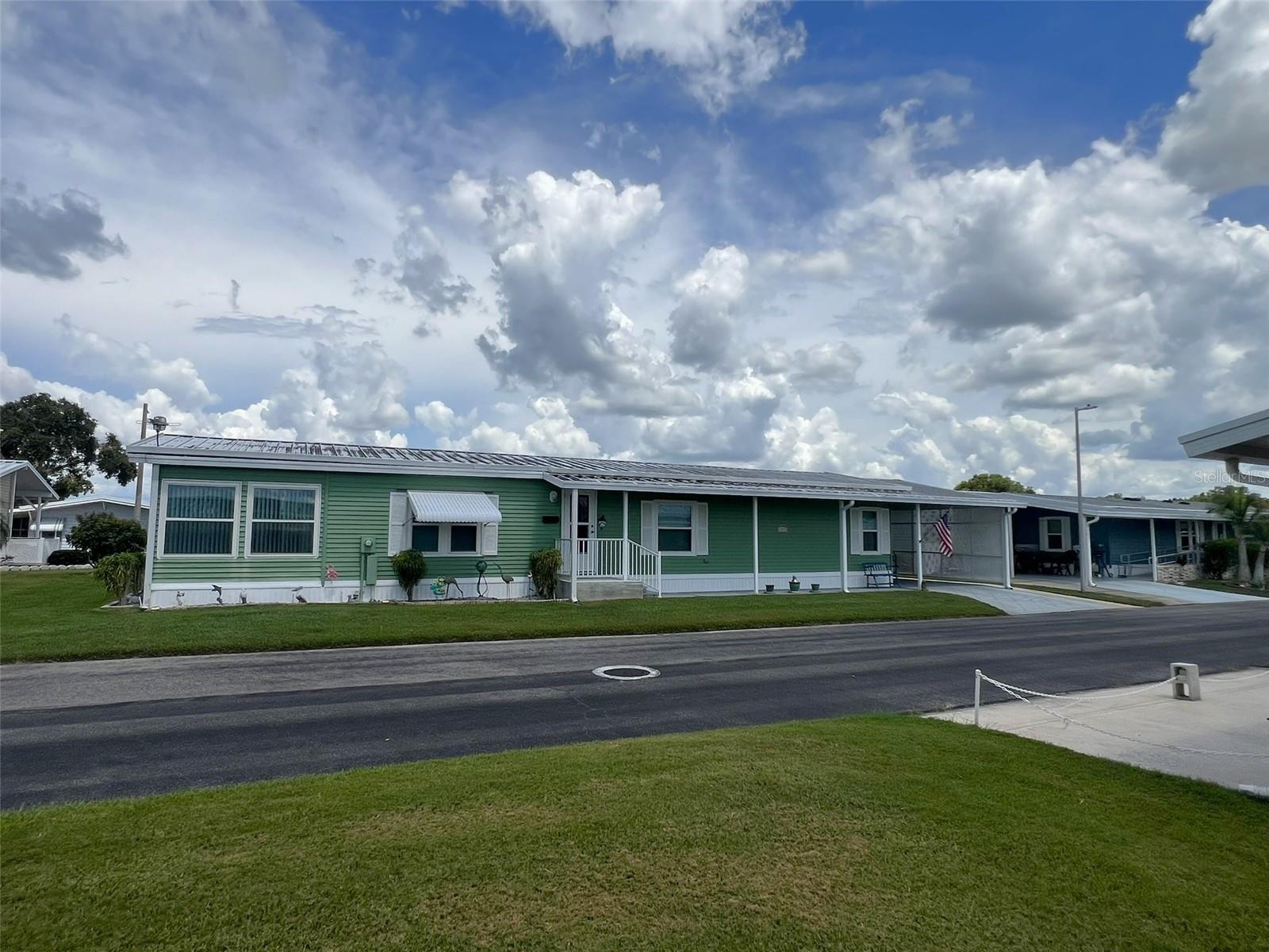 This spacious, move-in ready 2 Bedroom, 2 Bathroom manufactured home in the 55+ Floral Lakes Community in Bartow, Florida features double pane windows; metal roof; new ceiling fans/lights; a large galley Kitchen with granite countertops, ample storage & breakfast nook; a Dining area with built in cabinetry and hutch; a large Living Room and enclosed Florida Room, with access to the rear covered porch. Primary Bedroom features walk in closet and en-suite bathroom with linen closet, large vanity, and tiled shower enclosure with glass door. Guest bathroom also features a tiled shower enclosure with glass door. Ceramic tile and wood laminate flooring throughout the home. Full size washer and dryer (included) are located in the indoor laundry room. The (3) exterior doors in this floorplan allow ease of access in and out of the home. Outdoor storage/workshop; single car carport, plus covered patio for outdoor living. (Golf cart sold separately.)
Located in central Florida, between Tampa and Orlando, this golf cart friendly community is near the Bartow Civic Center, Bartow Public Library, and Mary Holland Park. Here you OWN YOUR LAND (no lot rent) and pay low monthly HOA fees. The Floral Lakes community offers access to a stocked pond with community boat ramp and dock. Clubhouse amenities include recreation space, shuffleboard, putting green, and large heated swimming pool. Social clubs, dances, exercise, pot lucks, and MORE! Association approval is required for purchase. Call your Realtor today for more information and to schedule a showing!
