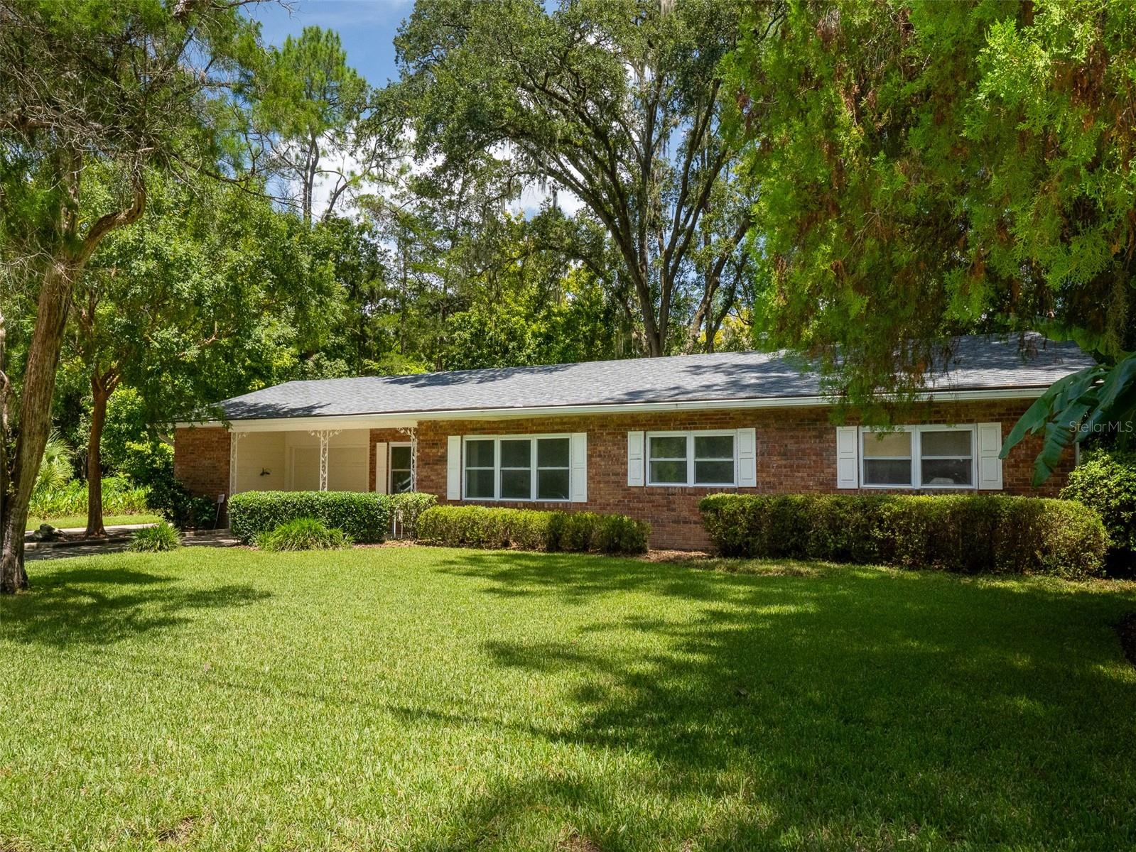 Don’t miss this one story brick house that has been a wonderful single family home as well as a successful rental. The fantastic location close to the university and sports complexes, shopping, schools, golf course, and a park with a pool and tennis courts make it a great opportunity for any Buyer. Beautiful kitchen with custom wood cabinets, granite counters, higher end appliances, a built in pantry, and a breakfast bar all open to the family room. From there the large glass pocket doors lead to the inviting light & bright Florida room. The primary bedroom has an en-suite with a large tiled shower and grab bars. A separate indoor laundry with adjoining craft or storage area and built in cabinetry , an oversized one car garage , plus a paved RV parking area all contribute to the livability of this home. Enjoy the large, fenced backyard with mature landscaping and a nice patio area. A brand new roof adds to your peace of mind when you purchase this great property.