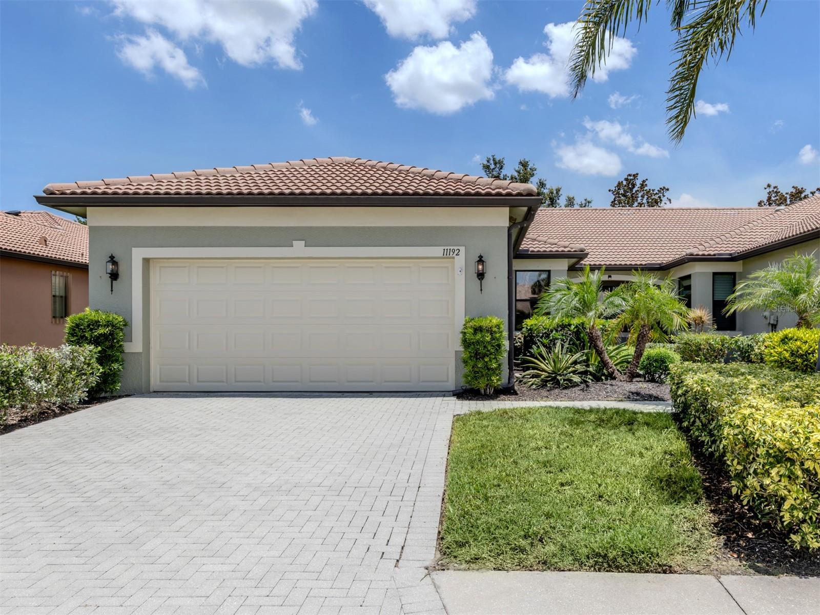 Welcome to this immaculate Bella Vista end unit villa, designed for effortless living and surrounded by the resort-style amenities of Venetian Falls. This bright and airy home features an EXTENDED, screened lanai with serene preserve views, perfect for enjoying your morning coffee with local wildlife. The interior showcases thoughtful upgrades, including elegant crown molding, beautiful wood flooring, and 16-inch tiles laid on the diagonal. The heart of the home, the kitchen, boasts granite countertops, premium all-wood cabinetry with pull-outs, and a large granite island perfect for casual dining and entertaining. The spacious master suite offers two custom-shelved closets and a spa-like bath with a generous walk-in shower. Modern conveniences abound with wiring for surround sound in every room and on the lanai, plus built-in cabinetry to keep your media organized. Spacious guest suite. The custom showroom garage features mica flake flooring and a unique pull-down Life Style Screen. Venetian Falls is a vibrant, gated community offering an array of amenities: a heated lap pool, spa, fitness center, billiard room, internet café, and various courts for bocce ball and putting. Enjoy a truly maintenance-free lifestyle with included lawn care, pest control, and basic cable. Situated ideally near shopping, stunning beaches, diverse dining, and charming historic Main Street Venice, this villa offers the ultimate in convenience and resort-style living.