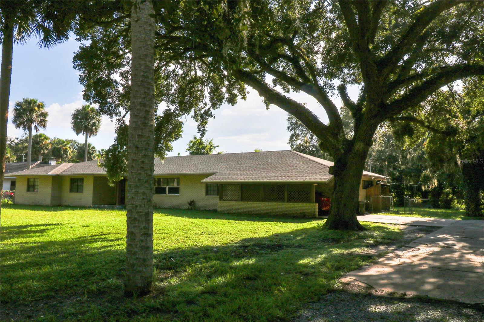 Just five houses from the shores of Lake Monroe, this hidden gem on the peaceful, no-thru-traffic Crescent Blvd is bursting with potential. Set on three spacious lots totaling nearly half an acre, and surrounded by charming, well-kept homes, it offers a rare opportunity in a sought-after location.
The block construction home needs significant rehab, but its solid bones, generous layout, terrazzo floors, and large screened-in porch provide the perfect canvas for your vision. Rooms are spacious, and the property boasts a current termite bond with Massey, inspected quarterly for peace of mind.
Enjoy a rural, tucked-away feel without sacrificing convenience—downtown Sanford is just a short golf cart ride away. Wildlife enthusiasts will love the frequent visits from wild turkeys, sandhill cranes, and the occasional peacock, while Lake Monroe’s sparkling waters can be seen from the front yard.