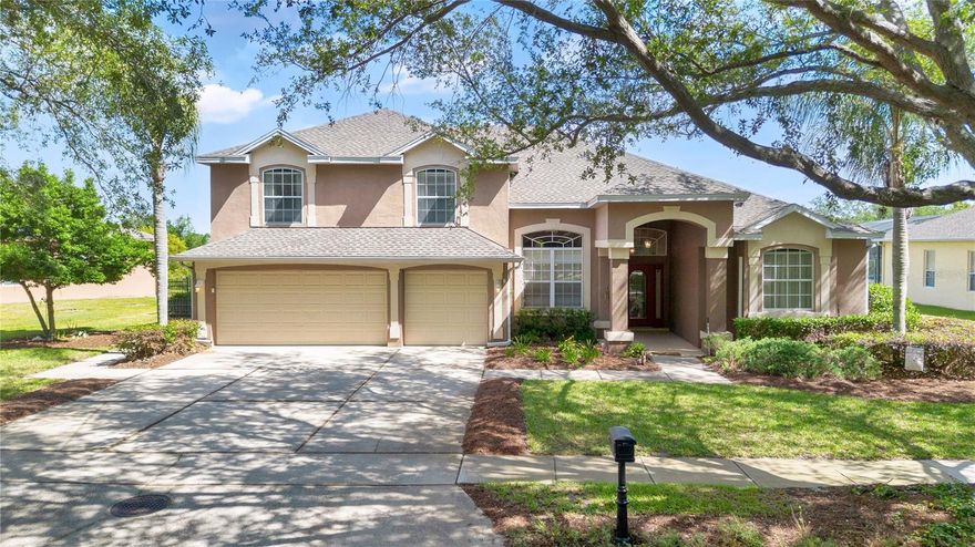 There's room for everyone here. Nearly 3,300 square feet with five beds, three baths, a three-car garage, a pool, and no rear neighbors tucked behind the gates of Westover Club in Windermere. TStep inside and the house opens up. Soaring ceilings, a two-story family room with a fireplace stretching up the wall, a catwalk overhead, and sightlines that carry all the way through to the pool. Gorgeous Allen & Roth tile and baseboards run throughout the downstairs, tying it all together. The kitchen anchors the middle of it all with a 10-foot granite island, GE Café dishwasher, Kraus 60/40 sink, and Moen Motionsense faucet, with deep bar-height cabinets on the back doubling the storage. Living, family, and dining rooms all flow from here under the same vaulted roofline. Cook, entertain, collapse on the couch. Homes like this one don't come around often. Two sets of oversized sliders pull you onto the screened lanai, repainted and re-screened in 2024. Covered seating, a pool, and patio space beyond the cage. The downstairs primary suite stretches long enough for a true sitting area or home office, with its own sliders to the patio. The en-suite is a full retreat: dual vanities, a walk-in shower, a soaking tub, a private water closet, and two separate walk-in closets. A second bedroom and full pool bath sit across the home in a split plan, with a French door nearby to the patio. The right setup for guests, in-laws, or a long-stay visitor who wants their own door. Upstairs, three more bedrooms, one currently styled as a dedicated theater room with an 8-foot built-in screen, Epson projector, surround sound, and staggered seating. A full bath serves the upper floor. The laundry room has cabinets above and below the sink, and deep storage tucks under the stairs. Big-ticket updates are done. New roof, new upstairs HVAC, and new black metal fencing, all in 2023. Westover Club is gated, tree-lined, and quiet, with community tennis, a playground, and a sand volleyball court. You're minutes from the Walmart Fresh Market on Apopka-Vineland, ten to Restaurant Row on Sand Lake, fifteen to Disney and Universal, and twenty to downtown Orlando. Winter Garden Village and the Mall at Millenia are easy runs from here. Zoned for Thornebrooke Elementary, Gotha Middle, and Olympia High. Windermere gates, Dr. Phillips dining, Disney minutes away.