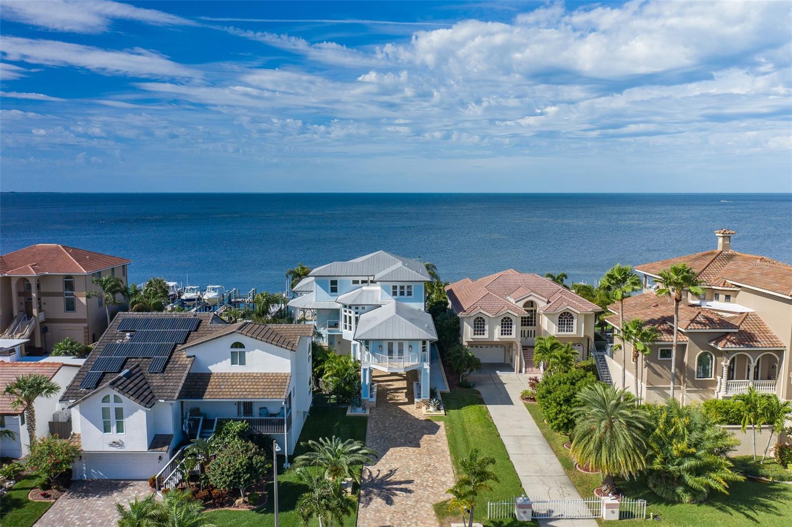 A rare opportunity with a prime location directly on the Gulf (no canals & deep access)! This completely updated 4Bed 4Bath one of a kind move-in ready home is just 6 doors down from the Gulf Harbors Private Beach (Dock has stairs that allow you to walk to the beach). Enjoy the luxury of over $1.5mill in high end updates and upgrades. As you approach this home you will notice the long pavered driveway that offers 100ft of setback and privacy from the street. Take the pavered spiral stairs that lead to the front door or the elevator. Enter through the new hurricane rated front door and instantly be taken in by the openness and breath taking water views. The 2nd floor offers the kitchen with top-of-the-line appliances, Living room, Dinette, Dining room. The kitchen is equipped with Wolf appliances, 2 ovens, and subzero fridge/wine fridge and Cove dishwasher. 3 Bedrooms, 2 Bathrooms (one jack and jill), laundry room with double washer and dryer. The second floor also offers an expansive covered balcony off of the kitchen and living room. The third floor has an expansive master suite that was just completed in 2022, that includes an oversized shower, vanity with hidden electricity, wine/water fridge, master closet with center island, and private balcony. Bonus space offers a lux kitchenette, gym/in-law suite, and full bath with spa like shower. The backyard includes upgraded saltwater pool, spa and pool equipment with heater/cooler. Enjoy the shade with an extendable UV sunshade and tiki gazebo when entertaining or just relaxing. The dock was redone and extended in 2019 with a 10k boat lift and in 2021 an additional 33k pound lift was added. An additional tiki at the dock is great for watching the breathtaking sunsets! Deep water access even at low tide! Enjoy your own private beach behind the home at low tide with clean white sand! There is an extensive list of upgrades available. A few of them include gym and exterior have "Big Ass Fans", Electric shades throughout home (Bedrooms have black out shades), impressive whole house including exterior sound system, 2 New AC systems with HEPA filtration with new duct work on 3rd floor and UV light systems 2023, all new hurricane windows and doors, new flat roofs, all new paint inside & out, all new kitchen, all new fixtures throughout home, all bathrooms gutted to studs and remodeled, whole house commercial water softener, new hot water heater 2023 and tankless water heater in master suite, high-end custom closets in every room, garage floor has high gloss custom epoxy, new insulation, Entire home custom security system with 16 HD cameras and so much more. Don't miss this opportunity to own a one-of-a-kind waterfront masterpiece!
