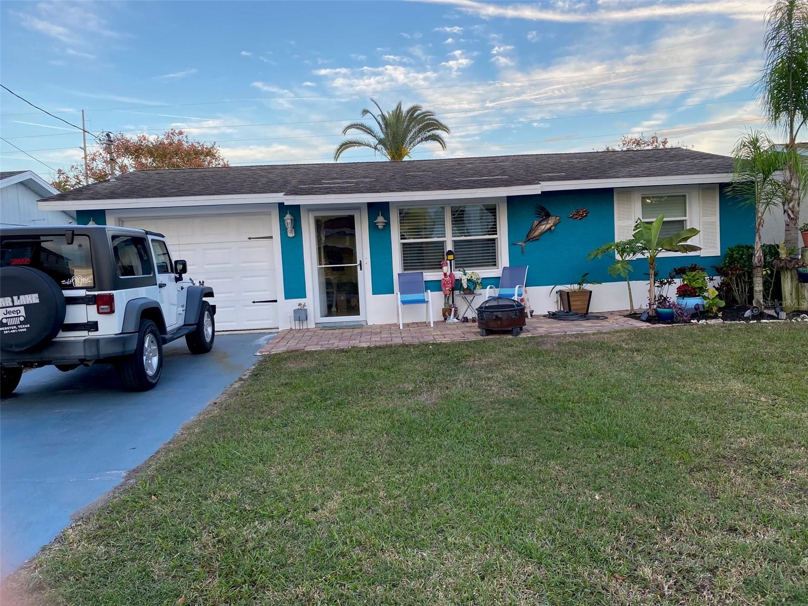 This beautifully remodeled 3 bedroom 2 bath home offers turn key luxury with high end upgrades throughout. Starting with custom epoxy flooring in ocean tones to the fully updated kitchen cabinetry, subway tile backsplash and stainless steel appliances. Every detail reflects modern style and comfort. The private backyard is a true sanctuary, featuring a covered lanai, tropical landscaping, and a built-in outdoor bar-perfect for entertaining. You will enjoy direct water access to the gulf with a jet ski floating dock and a covered boat lift, ideal for Florida's boating lifestyle. There is a tankless water heater for energy efficiency,t he option of being a fully furnished sale, has a water softener and projection tv and screen. It is ideal for short-term rental, seasonal, or a forever home. Close to the beaches, islands, shopping and top-rated schools.