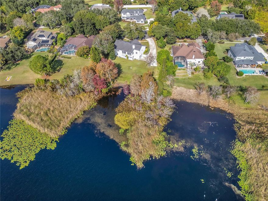 This truly unique lakefront retreat offers peace, privacy, and exceptional versatility. The home features six bedrooms and four bathrooms, including a private two to three room in-law suite on the lower level with its own full bath. This space is ideal for multigenerational living, extended guests, or added flexibility.  The lower level storage/bonus room could be converted to a 2nd kitchen with proper permitting.

The main level includes four bedrooms and three bathrooms, two of which have been beautifully updated. A flexible bonus space provides the perfect spot for a home office, or playroom to suit your lifestyle needs.

Breathtaking lake views can be enjoyed from both the upper and lower outdoor living areas, with a stunning balcony overlooking the water that creates the perfect setting for relaxing or entertaining. Adjacent to the in-law suite is an impressive five-car garage, ideal for car enthusiasts, hobbyists, or anyone needing additional workshop or storage space.

Engineered hardwood flooring runs throughout the main living areas, and the home sits on an expansive lot just under one acre. Designed to live like a single-story home with added bonus space, it also includes a large downstairs storage room for extra convenience.  Closets arE abundant and the primary closet is a HUGE walk-in.

Located in a quiet, well-maintained subdivision with low HOA fees, the home is just minutes from The Mall at Millenia, Dr. Phillips Restaurant Row, Trader Joe’s, Whole Foods, Universal Studios, I-4, and everything Orlando has available. 

The home has been thoughtfully updated over the years, including a roof replaced in 2013, water heater in 2020, and a main AC system replaced in 2021. Interior improvements include engineered wood flooring installed in 2020, interior paint in 2022, a beautifully renovated primary bathroom in 2022, a whole-house water filtration system added in 2022, and updated lighting and ceiling fans in 2025. The second bathroom was updated in 2025, along with fresh exterior paint this same year. Additional features include well water for irrigation, a whole-house vacuum system, and the rare convenience of two washers and two dryers, making this home especially functional for larger households or multigenerational living.  One set is located on each level.

This is a rare lakefront opportunity that truly stands out and will not last long.