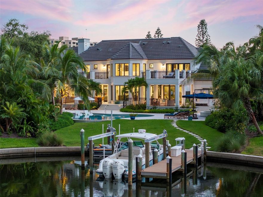 Rare opportunity to acquire completely remodeled waterfront residence (Finished in 2023) on Sarasota’s most prestigious barrier island of Longboat Key, in the coveted Harbors enclave of Bay Isles. Orchestrating exceptional style, comfort, and barefoot elegance, this five-bedroom home stirs the senses. Completely redesigned by renowned architect Clifford Scholz, construction was completed in October 2023 after two years. This home is filled with top of the line finishes that merge with a thoughtful floorplan and an endless list of custom touches. Set on a dreamy corner lot with basin frontage that leads straight into Sarasota Bay, the outdoor experience was perfected by award-winning landscape architect Michael A. Gilkey. Upon entering the foyer, your eyes are immediately drawn to the oil rubbed, hand scrapped wood floors and extensive woodwork throughout the entire home. The formal living room, anchored by a custom wormy butternut bar, coffered ceilings with hidden air vents and speakers and a wealth of french doors, which leads directly to the outdoor living room, protected by retractable screens and shutters. Enter the chef’s kitchen complete with Viking and Subzero appliances, Italian soapstone countertops, custom Campbell cabinetry, Miele built-in coffee station and ice maker in the beverage center, and two concealed Cove dishwashers. Rounding out the kitchen is the butler’s pantry with additional refrigerator, laundry, and custom cabinetry for storage of all your entertaining essentials. Enjoy morning coffee in the connected family room with gas fireplace and built-in bookshelves and cabinets. Conveniently located steps away is the large outdoor kitchen with grill, power burner, smoker, and custom dining table for twelve. Large media room contains custom leather theater seating and wet bar. Under the staircase is the climate controlled 506-bottle wine cellar with old-world marble floor. The breathtaking dining room includes custom built furniture imported from Italy, Juliet balcony, and wet bar. Two bedrooms finish out the first floor, one complete with custom built-in office. The pool bath has floating wood counters made from antique wooden boat slabs imported from France, mother of pearl shower wall tiles, and Waterstone fixtures. The primary suite is serene and spacious and opens to its own private terrace. Winding down every day becomes a cherished ritual in the primary bath which boasts large copper tub and Waterstone fixtures throughout, imported crema tile in zero clearance wet room that contains rain head, two handhelds, marble bench, and electronic privacy glass. The large ensuite closet is fully custom with mahogany wood slab island. A second-level primary bedroom offers an ensuite bath and its own private terrace. There is an efficiency bedroom, complete with ensuite bath with tub, and kitchenette with full-size fridge. The back yard pampers with a resort-like experience with pool with sun shelf, spa, custom firepit, outdoor shower and dog wash, and pet turf. The HOA maintains the seawall. The boat lift, jetski lift, and corresponding pilings are new, along with new Azek PVC decking material. Other notable items: 36,000 KW Kohler generator which powers the entire residence, Lutron smart home system, laundry room on each level of the home, three-car garage, and hidden retractable electronic Lutron shades throughout.
