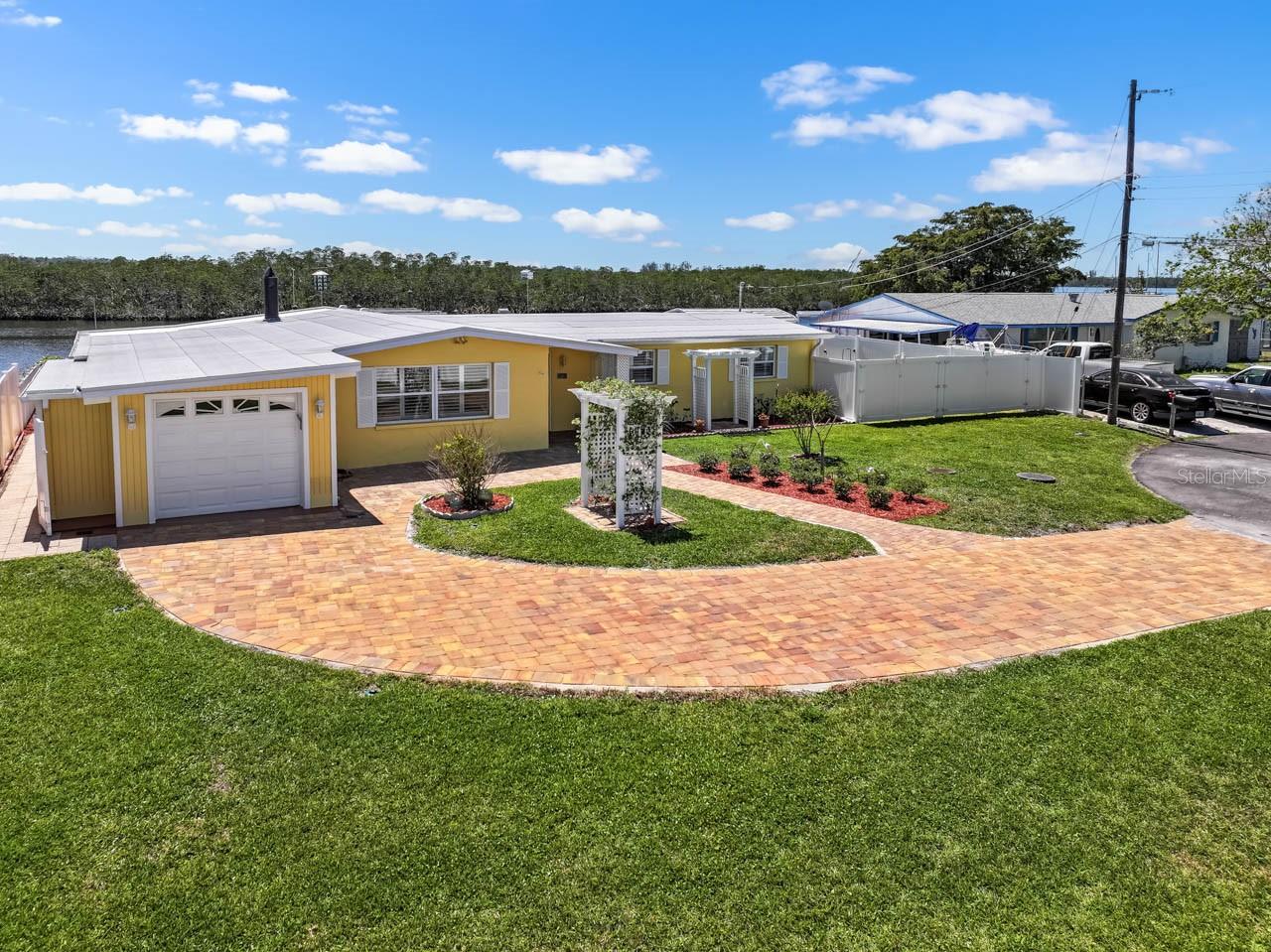 Idyllic 3 bed, 2 bath, WATERFRONT home with a NEW ROOF (September 2024), FRESH interior & exterior paint, NO HOA/CDD, completely renovated, and move-in ready! Homeport your sailboat, catamaran, cruiser, or trawler on the 45-ft face DOCK in deep water on the main channel of the Little Manatee River less then one mile from the open water of Tampa Bay, and on out to the Gulf. In addition to the face dock, there is a 35-ft slip plus a 6k/12k BOAT LIFT, and a covered BOAT HOUSE WITH LIFT. Electric and water at all berths! Enjoy tranquil privacy, as the 95 feet of riverfront faces the preserve. The interior of this beautifully updated coastal cottage features NEW ITALIAN PORCELAIN TILE and PLANTATION SHUTTERS throughout! There are river views from all rooms and a functional WOOD-BURNING FIREPLACE. The kitchen has CUSTOM HICKORY CABINETRY, GRANITE COUNTERTOPS, STAINLESS STEEL appliances, and BREAKFAST BAR with pendant lights. The spacious primary bedroom has NEW CARPET, a NEW ceiling fan, an EN-SUITE BATHROOM, and opens through FRENCH DOORS to the river. Hear and see porpoises and manatees frolicking and feeding in the water as you entertain guests year-round on the expansive 500+ sqft COVERED & SCREENED LANAI - an exceptional extension of living and dining space. Beside the boathouse is plenty of other storage in the large shed and two smaller side sheds. The property is FULLY FENCED and located at the end of a CUL-DE-SAC. It has an ARTESIAN WELL for irrigation, yard, and dock use to help substantially reduce the county water bill. There is plenty of room on this large lot to add a pool and an additional 3-car garage. Additional features include: PAVER DRIVEWAY, covered front entry, attached 1-car garage, backyard pergola, OUTDOOR SHOWER, interior laundry room with built-in cabinetry & shelving, CHAIR RAIL & WAINSCOTING, updated bathrooms, and a WALK-IN CLOSET in the back bedroom off the Family Room. This remarkable home is a boater's dream come true, and the location is truly one-of-kind. Don't miss your chance to live the Florida waterfront lifestyle!