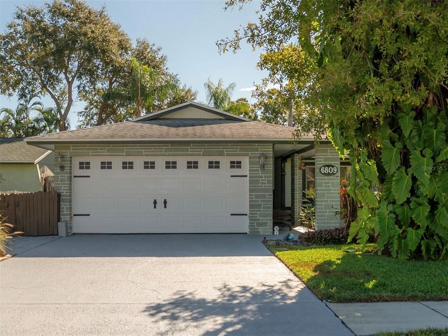 Discover the perfect blend of comfort, convenience, and Florida living in this beautifully maintained 3-bedroom, 2-bath pool home in the sought-after Bonnie Glynn neighborhood. From the moment you arrive, you’ll notice the pride of ownership — from the lush, manicured landscaping with custom lighting to the welcoming front porch and spacious lot. Inside, the open layout is ideal for relaxing or entertaining, featuring a nice gala kitchen with granite countertops, stainless steel appliances and easy access to the bright living and dining areas overlooking the sparkling pool. Tile floors flow throughout the main living spaces, while bamboo flooring in the bedrooms adds warmth and charm. Natural light fills each bedroom, creating an inviting and comfortable atmosphere, while a large window in the primary suite offers a beautiful view of the backyard. Step outside through brand-new hurricane-impact sliding doors to your own private retreat, complete with a large pool, separate hot tub, pergola and two storage sheds surrounded by tropical landscaping. The oversized two-car garage includes hanging storage, attic access and laundry hookups, while the side of the home provides additional space for a trailer or small boat. Ideally located just minutes from shopping, dining, beaches and schools, 6809 Sandwater Trail is move-in ready and truly captures the best of Tampa Bay living. Schedule your showing today!