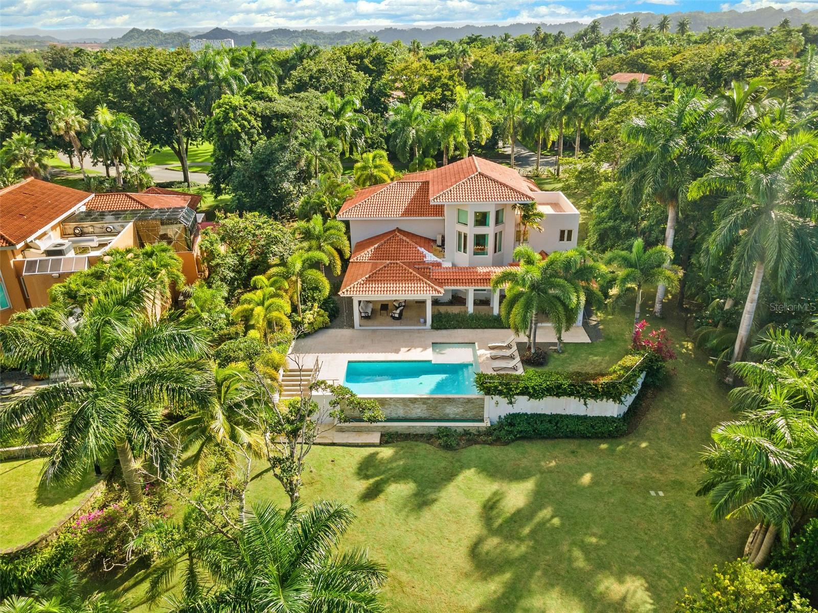 This sun-drenched and spacious property has 5 bedrooms, 6.5 bathrooms over 6,000 sq. ft. and sits within a lush and tropical community. The open and contemporary property boasts cathedral ceilings, tiled floors throughout, a dream kitchen with all high-end appliances and a secluded, fully-furnished outdoor patio/backyard. Large Infinity Pool overlooking the East Golf Course
The Dorado Beach East community is private, gated, family friendly and offers a wide range of facilities that you can enjoy. The facilities include scenic pools, clay tennis courts, basketball and beach volleyball courts, a basic gym, a game room, a 3-par golf course that winds through the neighborhood, and an aviation themed park which has a custom water park and sand park.
Located within the Dorado Beach Resort, since it is a 2,000-acre natural reserve most of the communities are 1-3 miles away from the beach and Hotel. This being said, the entire resort is interconnected via golf cart trails, meaning that you can have easy access (walking or in golf cart) to the different communities and amenities within this Resort.
