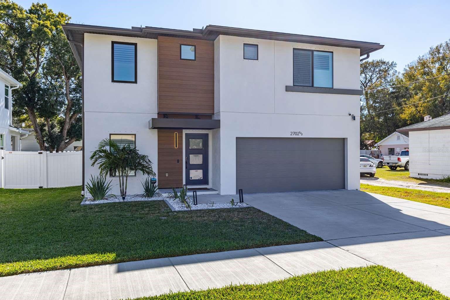 This one year old new construction home is the perfect opportunity for you! This meticulously maintained "like new" home boasts 5 bedrooms, 2.5 bathrooms, 2 car garage and over 2,000 sq ft of living space. You'll be sure to fall in love with the modern coastal aesthetic and beautiful finishes throughout the home. There are numerous upgrades throughout the property including plantation shutters, high end appliances, designer fixtures and finishes, SimpliSafe security system. The layout is perfect for entertaining with an open concept kitchen, living area, and custom built-in bar. Outside you will find an oversized screened-in covered lanai (w/retractable screens) and large fully fenced in backyard to enjoy the amazing Florida weather. Backyard includes brand new pool surrounded by turf and your own putting green. Head upstairs to find the expansive owner's retreat with a massive walk in closet and pristine bathroom. Down the hall are two additional bedrooms, walk in laundry room, and full bathroom. You will also find a bonus / media room equipped and wired for 3 TVs and built in coffee bar with fridge. Also has a built in gym in the garage that retracts to still fit 2 cars. This centrally located West Tampa gem won't last long, get in before it's gone! Owner is a licensed Real Estate agent.