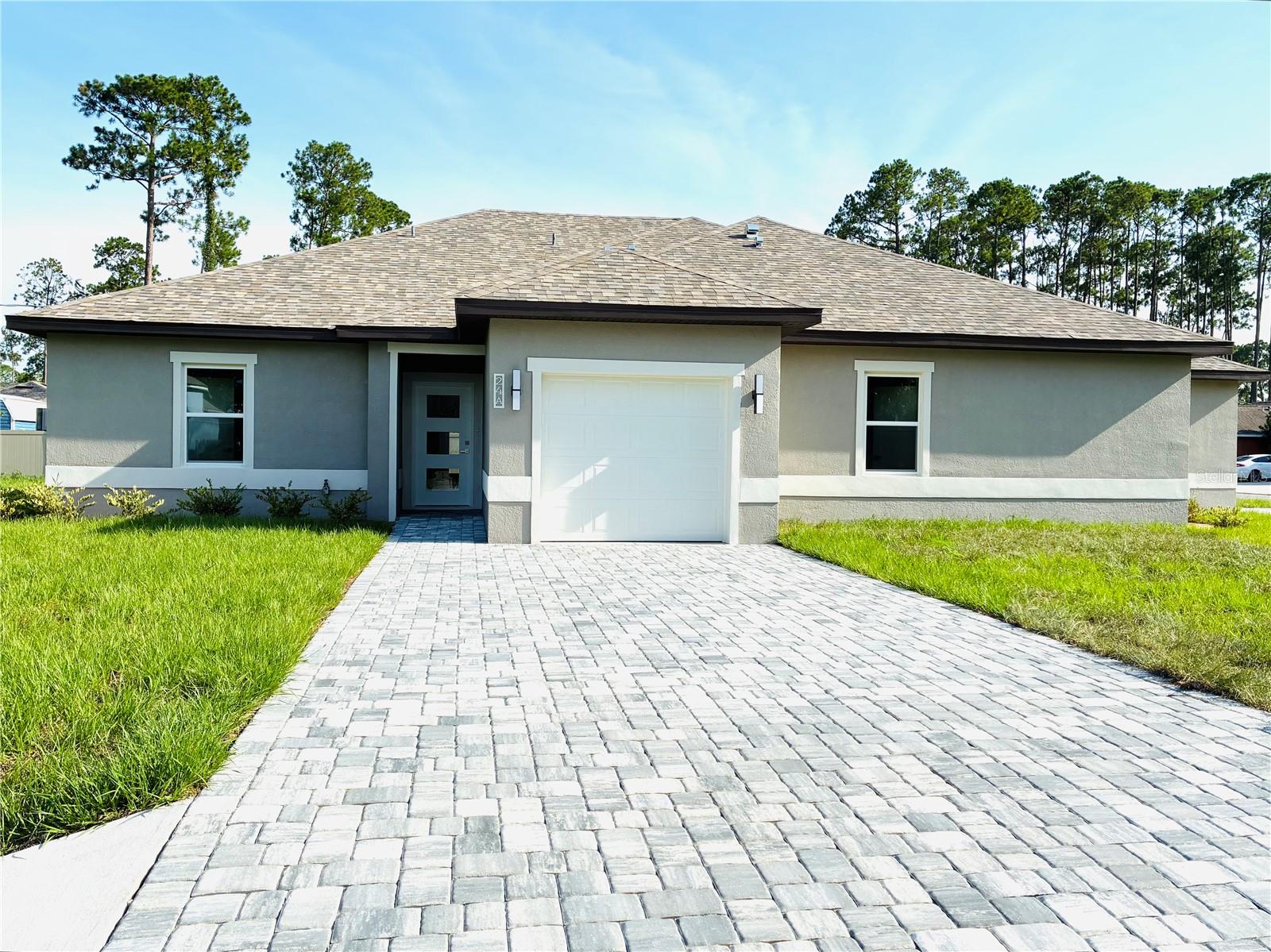 Gorgeous, BRAND NEW duplex, situated on a corner lot: Spacious 3 bedrooms with walk-in closets, 2 baths, a spacious covered porch, and a 1-car garage with a garage door opener system. The open-concept kitchen features stainless steel appliances, including a glass-top stove, 42-inch kitchen cabinets with granite countertops, and plenty of storage space. The great room provides ample lounging and relaxing space with generous circulation. The house features high tray ceilings and custom tile throughout. Bathrooms have high-top vanities with cultured marble countertops, and there are fans in all bedrooms. The two-car wide driveway offers four car spaces for each unit. Available now. Perfect location: close to schools, shopping, Town Center, hospital, and the beautiful Flagler beaches.