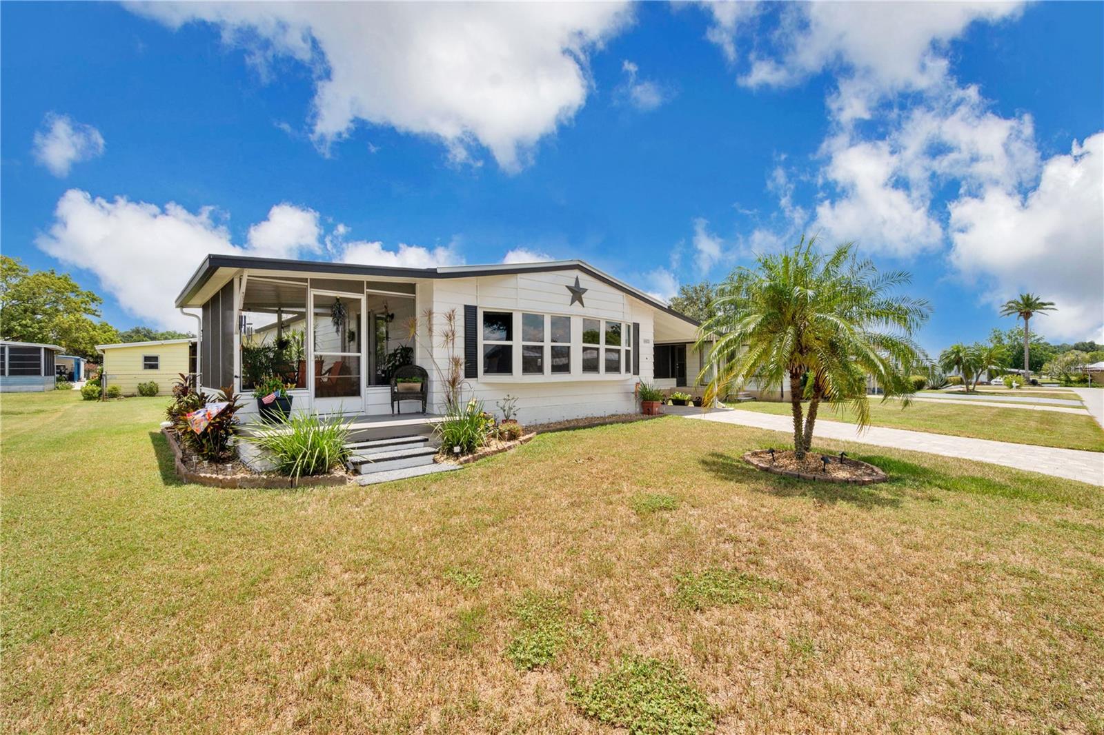 Welcome to this beautifully maintained 2-bedroom, 2-bathroom home in the highly desirable Foxwood Lake Estates, an active 55+ community in North Lakeland. This charming residence offers comfortable indoor-outdoor living with a screened, covered patio and an open deck—perfect for enjoying Florida’s sunshine or relaxing in the shade. Inside, you'll find a remodeled kitchen featuring open shelving (2018), a newer range, range hood, and refrigerator (2018), and a brand-new kitchen sink (2025). The shiplap accent walls (2019) in the living room, kitchen, and hallway add a cozy, farmhouse-inspired touch.
Practical updates include a metal roof (2022), epoxy-coated carport floor (2020), pavered driveway (2018), and a rebuilt exterior deck with durable simulated wood planks (2019). The interior laundry room comes equipped with a washer (2023) and dryer (2018). Additional improvements include updated ceiling fans throughout (2018), including a new fan in the primary bedroom (2023), tinted front windows (2019), and blinds (2018). The HVAC compressor was replaced in 2023 for peace of mind and year-round comfort.
Foxwood Lake Estates offers an incredible range of amenities, including a health fitness center, heated pool, outdoor covered spa, indoor sauna, two billiards tables, shuffleboard courts, and a stocked lake with a peaceful walking path. Residents enjoy a vibrant social calendar filled with potluck dinners, pancake breakfasts, bingo, dances, Bible studies, variety shows, and more—all centered around a spacious clubhouse with a game room and library. Located close to shopping, churches, and entertainment, this home offers not just comfort, but community and connection.