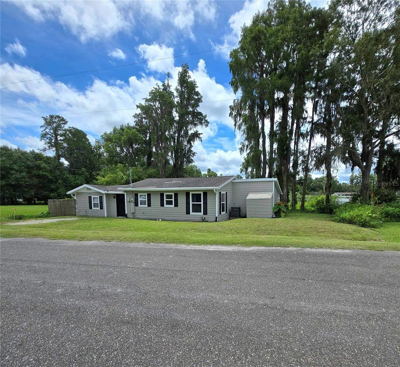 Tired of your neighbors being on top of you? Look no further. Get a rural country setting (on a FULL ACRE) in the city with no neighbor across from you or to your left while the neighbor to your right is 65 feet away. This 3/2 house (with over half of the acre going over 200 feet into the lake) has pristine lake views of Lake Sharon from the master bedroom/bathroom, living room, dining room, and third bedroom. The entire house has wood plank flooring (installed in 2024) and double pane windows throughout. The master bedroom is the size of almost two bedrooms and includes a large bathroom with a garden tub, walk-in shower and an additional closet. Both bathroom vanities upgraded in 2024. The entire kitchen (appliances, counters, cabinets) was remodeled in 2022. The backyard boasts a private 500-square foot wooden deck overlooking the lake in addition to a coy pond (currently not being used) and also a storage shed with room to store landscaping tools or alike. The AC is from 2021 and roof 2015. NO HOA/CDD and low taxes also make this a great rental property (long or short-term) due to such low monthly carrying costs.