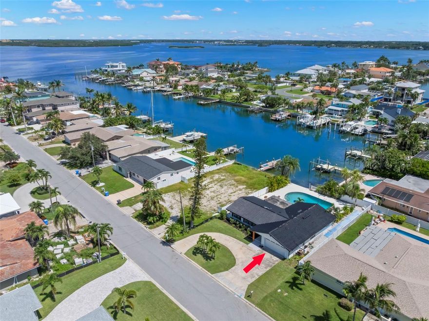 One or more photo(s) has been virtually staged. PRICE IMPROVEMENT!!  FULLY RENOVATED & MOVE-IN READY WATERFRONT POOL HOME!!  This 3 bedroom/2 bathroom oasis is located in one the most sought out areas on the coast, Isle of Capri in Treasure Island Beach.  From the moment you enter into this bright, vibrant spacious open floor plan, you realize you are finally home.  A massive living room and kitchen space will allow for entertaining family and friends. A CHEF'S DREAM... The kitchen has been revitalized with CUSTOM cabinetry featuring soft-close drawers, murphy door with hidden pantry, gorgeous quartz counter tops, brand new appliances which includes a SMART Samsung Bespoke 4 Door Flex Refrigerator and an induction cooktop.  The oversized island and the adjacent formal dining area will allow plenty of seating for those big dinner parties.  The primary bedroom is GRAND with plenty of space for your oversized furniture and a walk-in closet that will suit your storage needs.  The en-suite bathroom has been updated with a walk-in shower, glass enclosure and custom vanity with dual split sinks and a no touch, tankless SMART toilet.  The split floor plan offers 2 additional spacious bedrooms with a 2nd bathroom in between allowing for privacy throughout.  Time to retreat outback to your waterfront resort style pool area; offering a plethora of mature Areca, Christmas and Foxtail palm trees, two outdoor showers, shuffle board, screened in porch area, as well as plenty of space for the outdoor kitchen you have always wanted.  Just minutes to the breathe taking deep blue waters of the Gulf of Mexico Beaches.  Roselli Park is just a short distance away where you can enjoy a game of baseball, tennis, pickleball, basketball, shuffleboard and a newly transformed playground and dog park areas. It’s a short walk, bike ride or drive to all the local entertainment; shopping, bars and restaurants and the infamous Johns Pass! This abode and all it offers will make you feel like you are on vacation year round!