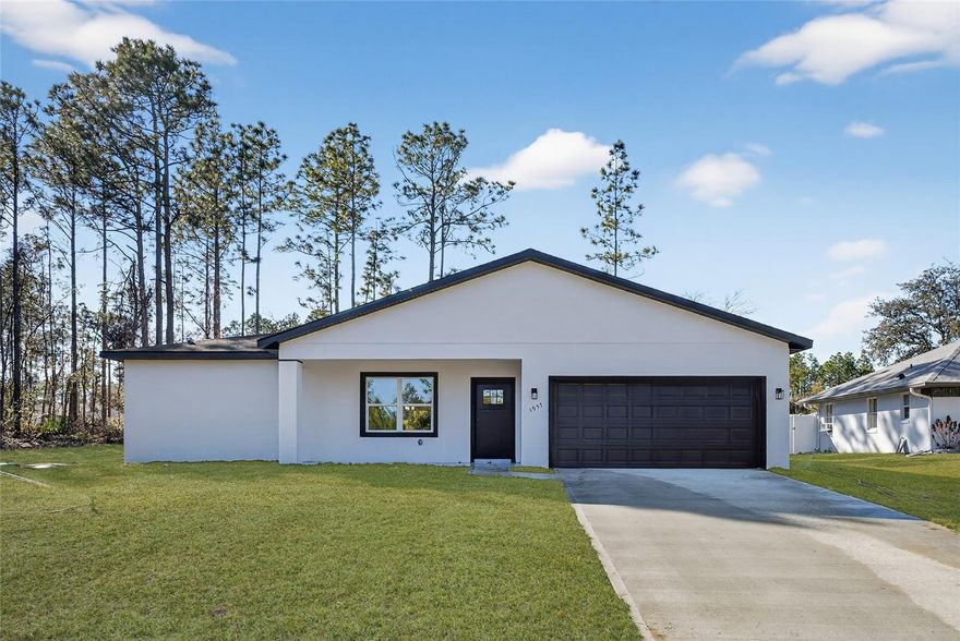 Enter into modern Florida living with this newly built four-bedroom, two-bath home set on a spacious 0.23-acre lot in a quiet Dunnellon neighborhood. The open floor plan showcases a sleek kitchen featuring white quartz countertops, shaker-style cabinets, stainless steel appliances, and a generous island ideal for daily use and entertaining. The split-bedroom design offers added privacy, with the primary suite highlighted by a walk-in closet, matte black fixtures and a porcelain-tiled en-suite bath. Built with concrete block and stucco construction, the home also includes a two-car garage and an expansive backyard with patio space for outdoor enjoyment. Just minutes from Rainbow Springs State Park, KP Hole Park and Rainbow River, this home provides convenient access to kayaking, tubing and some of the area's popular natural attractions.