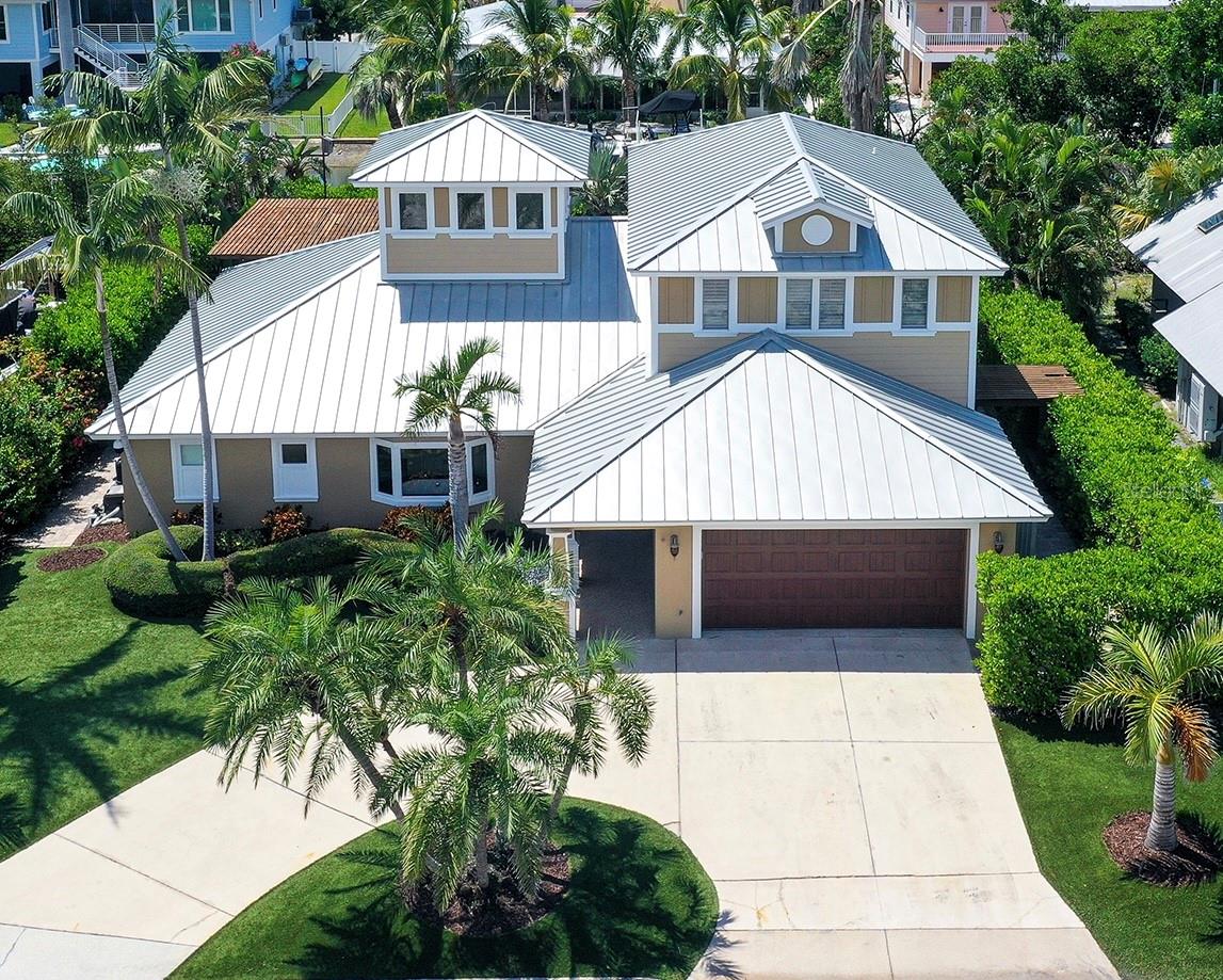 Experience refined coastal living in this stunning custom canal-front home, where timeless architectural elegance blends seamlessly with effortless luxury on the exclusive north end of Longboat Key. The attention to detail in this exquisitely renovated home is reflected in every thoughtfully crafted element and high-end finish, including furniture quality bespoke cabinetry, automated Lutron lighting and shade control system with remote access, standing seam metal roof, high-impact rated windows and doors throughout, low maintenance artificial turf, advanced whole house surveillance system...an endless list of luxuries.
Step inside the marble entry foyer which flows into the heart of the home where the living room, dining area and the spectacular chef’s kitchen come together framing the view out to the resort-like private backyard oasis. Walls of windows, doors, and the exquisite copula with gorgeous wood clad ceiling and motorized shades bathe the space with natural light. The magazine worthy kitchen is outfitted with furniture quality cabinetry, professional grade Wolf and dual Sub-Zero appliance suite, walk-in pantry, and a generous center island featuring wrap around seating and abundant storage. This impeccably designed space effortlessly balances form and function, making it ideal for everything from everyday dining and casual gatherings to grand-scale entertaining.
Just off the dining area, you will find the sunroom with a folding NanaWall allowing for privacy as needed; this room is truly flexible. The living room features a custom wall unit, in-ceiling speakers, and is pre-wired for surround sound enhancing the TV viewing experience. The hallway off the living room leads to the private second bedroom (can also serve as study/office), beautiful marble clad full bath, and an oversized laundry room lined with two walls of cabinets.
The first-floor primary bedroom suite boasts vaulted ceilings and a spacious walk-in closet outfitted with a custom closet organizer. The luxurious spa bathroom exudes timeless style with high end cabinetry featuring twin vanities, dual function whirlpool/air tub, oversized marble shower and a private water closet.
The grand walnut staircase with dramatic glass tile risers leads to the private self-contained second floor guest quarters featuring separate HVAC zone and water heater. The two upper bedrooms feature hand scraped hardwood floors, tray ceilings, ensuite marble baths and spacious closets with custom organizers. This floor also houses abundant storage with two large storage closets complete with built in shelving.
Outside, the coastal lifestyle unfolds in the ultra-private rear yard with mature and lush tropical landscaping, resort style saltwater pool with sun shelf and spa, four hole putting green, oversized pergola with motorized sunshade, outdoor shower, and a 53 ft dock on a deep water canal fully equipped with power, water, fish cleaning station and a 16,000+lb lift. Enjoy power boating or sailing on the Bay or Gulf with no fixed bridges to stand in the way. Just a few minutes by foot to the azure waters and white sand beaches. Ideal as a year-round residence or seasonal retreat, this incredible home captures the quintessential Longboat Key beach to bay lifestyle.
A rare opportunity not to be missed! Schedule your private showing today.