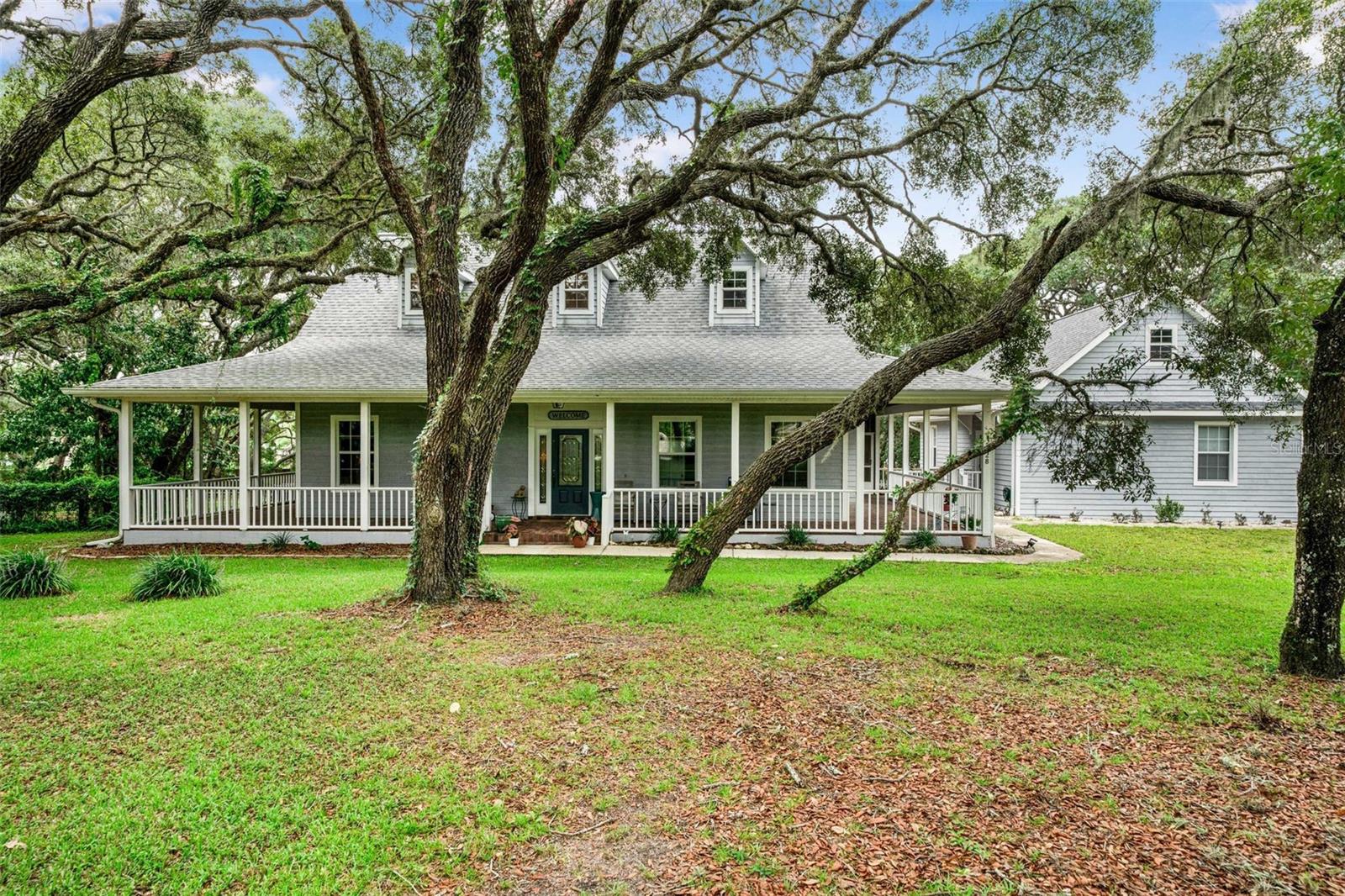 A glorious way to start your day, walking onto your rear screened porch overlooking 2 acres of majestic oaks and colorful plantings. Set back from the road gives you the feel of country living yet you are not far from shopping, medical facilities and fun. The kitchen and dining are a great space for large gatherings, there's easy access to the porch so you can open up the doors and flow between the two. The main bedroom is on the first floor, as well as a guest bath and laundry room. The guest rooms are large, comfortable and have great closet space. The three car garage is large with more storage capabilities and is connected by a breezeway so you are always under cover. This home has been designed with care and easy living in mind. Call today, don't delay.