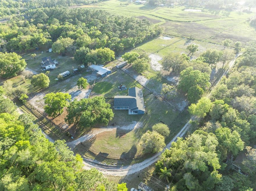 Escape to your own private Geneva retreat, where peaceful surroundings, open skies, and true country living come together on over 5 acres. Tucked away along a quiet country road, this property offers the space, flexibility, and lifestyle that rural buyers are searching for—whether for horses, multi-generational living, or simply room to breathe.

Thoughtfully enhanced in 2024, the home now features 6 bedrooms, including a private in-law suite with its own entrance and full bath—ideal for extended family, guests, or flexible living arrangements. Major improvements include a new roof, septic system, drain field, water filtration system, wood-look tile flooring, and fresh interior and exterior paint.  Inside, a split floor plan provides both privacy and functionality, with generous living spaces, a large utility room, and a 32’ x 12’ Florida room overlooking the acreage—perfect for unwinding and taking in the setting.  Designed with equestrian use in mind, the fully fenced property includes a classic center aisle barn with six stalls, including a foaling stall with private paddock, along with a wash and grooming area, tack and feed room, and matted stalls with fans. Fenced paddocks, a hay and equipment storage building, and a chicken coop add to the property’s versatility, with plenty of room to expand or customize.  For buyers seeking an updated acreage property that offers both function and freedom, this home delivers a rare opportunity to enjoy modern improvements within a true rural lifestyle setting.  All of this country life, and just a short drive to Oviedo, UCF and Sanford International Airport.  Zoned for Oviedo High School.
