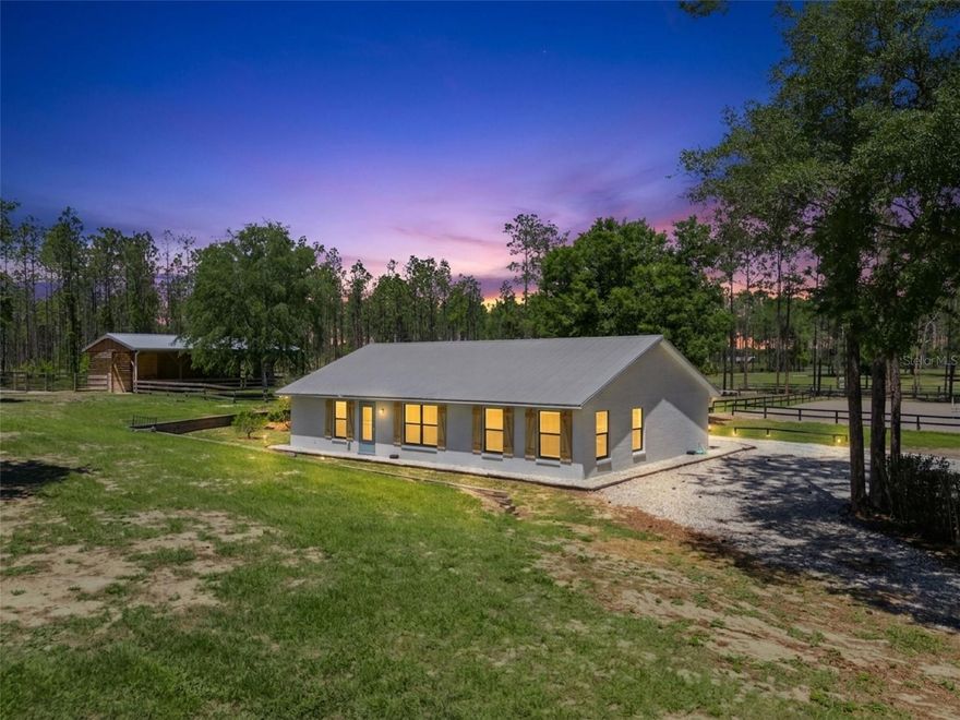 Designed with the serious equestrian in mind, this GATED HORSE farm has been recently UPDATED and features new 5’ no-climb and board fencing, along with a thoughtfully planned layout for both horses and riders. The property offers both tranquility and accessibility to premier equestrian venues! With nearly 5 ACRES of land, the property boasts SIX run-in shelters, including two that are ~ 12x12 and four 10x10s, each equipped with rubber mats and fans, and paired with private sand paddocks for optimal care and comfort. Near the run-ins you’ll find a 12x24 air-conditioned FEED room, plus an attached 8x20 covered storage area perfect for fencing materials and equipment. A generously sized air-conditioned TACK room (9X22) is outfitted with a dryer, bridle hooks, and racks to accommodate saddles, saddle pads, leg wraps, and helmets. An additional 9x22 air-conditioned room sits adjacent to the tack room and provides flexible space for an OFFICE, lounge, or hobby use, with access to a unique two-story cat and rabbit condo connected to both indoor and outdoor enclosures. This building also includes an oversized one car garage, which is suitable for your mower and supplies, and includes a half bath, utility sink, and ample shelving. Additional amenities include three grooming stalls and one wash stall, all complete with fans, mats, saddle racks, and bridle hooks, plus convenient overhead storage and room for a vehicle. The irrigated 160x120 riding ARENA features a blend of sand and synthetic stabilizer footing, ensuring excellent rideability year-round. The property also boasts three irrigated GRASS PADDOCKS and a large sand paddock (partially irrigated), offering versatile turnout options. Two wells are in place, one runs everything except the irrigation and the 5HP irrigation well is on the newer side (~ 4 years old). Infrastructure highlights include a remote-controlled Mighty Mule front gate, perimeter electric fencing, and irrigation servicing both the arena and grass paddocks. The spacious and fully updated (2025) 3 bedroom, 2 bath concrete block home features an interior laundry room, screened-in patio overlooking the arena, quartz counters, spa-like baths, and tile flooring. Ideally located just 15 minutes from the charming city of Mount Dora where you can enjoy waterfront dining, historical vibes, and shopping, and just over an hour from Ocala and the renowned WORLD EQUESTRIAN CENTER. Multiple grocery stores, coffee shops, and dining are less than 10 minutes away. A rare opportunity to own a turnkey equestrian retreat in a highly desirable area—schedule your private showing today! Measurements are approximate. Buyer to verify all measured areas for accuracy.