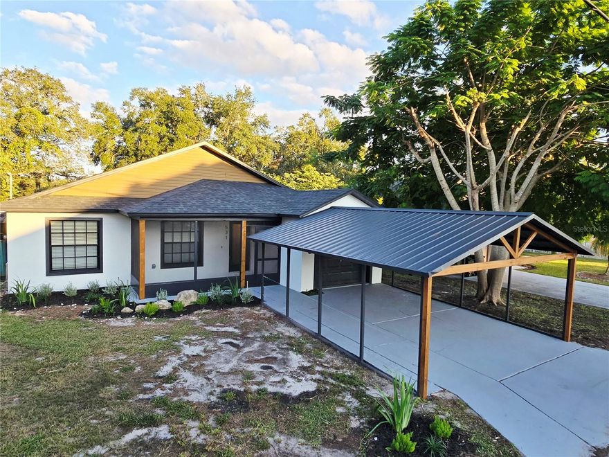 Welcome to Elegance! - 2025 Fully Renovated to Perfection! This contemporary “Barn-Style” house renovation was meticulously crafted to balance the current modern design trends without losing the essence of what a Florida property is meant to provide - Step inside this beautiful “ready-to-move-in” home, where you will be welcomed by an exquisite interior design palette concept, a new gourmet mesmerizing kitchen, a rustic tile mediterranean flooring, two gorgeous spa-inspired bathrooms, new contemporary light fixtures, top quality finishings and a breathtaking “Florida-Sunroom” for the family to gather together, enjoy the abundant natural light, the clean air that a “green room concept” brings and an additional “Wine Bar Cabinet & Grill” area to provide a getaway retreat without leaving your home. The new interior kitchen is a chef’s dream. Custom-built designer cabinetry, with oversize 42” wall cabinets, boasting quartz countertop, open shelving, new stainless-steel appliances, built-in microwave, fully wall backsplash finishing and a “waterfall” center island with plenty of space for the family or friends to gather around and enjoy the occasion. Enjoy the comfort of these two captivating spa-inspired bathrooms that showcase modern fixtures, dual vanities, vessel sinks, fully tiled shower, shelving's and exquisite marble accents. Once you step outside, you will be welcome to a NEW ROOF Replacement (2025), HVAC system was replaced in 2020, water heater in 2022 for your convenience and peace of mind. Surrounded by a modern "maintenance free” architectural landscaping, an oversize “Barn-style” carport that can be used for the family or friends to gather outside and enjoy the Florida weather or an additional parking space. This corner-lot property is located in a quiet and family-friendly neighborhood with no HOA restrictions. However, if you are looking for a change of scenery, this property is located just 5 minutes away from the iconic Lake Lotus Park, nearby fine dining, local shops, convenience stores and plenty of different entertainment venues. Don’t Miss Out on This Incredible Opportunity—Schedule your Showing Today and Experience the Finesse of your New Home!