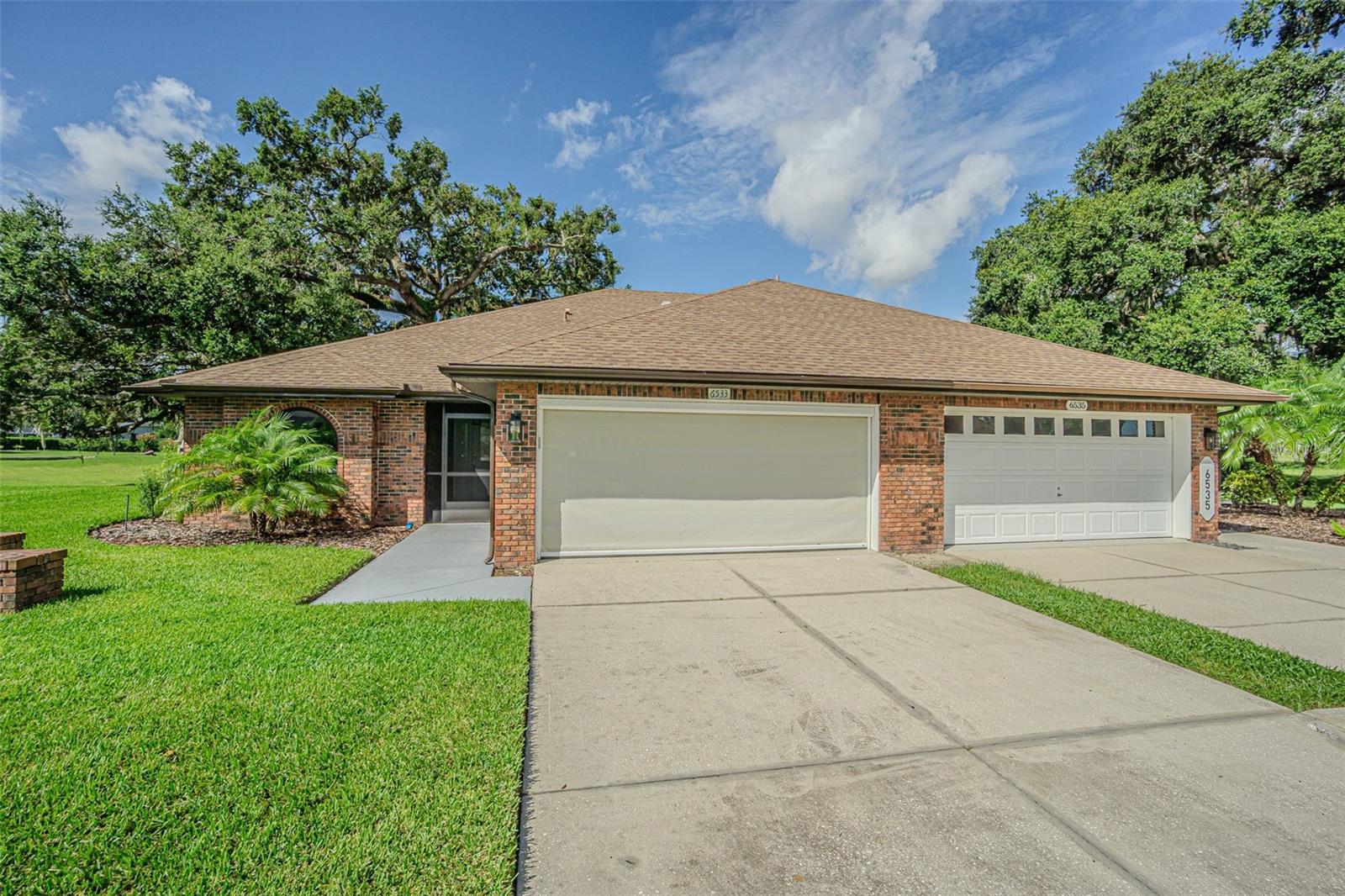 Maintenance free BRICK villa is BETTER than NEW and Ready for YOU! This beautifully updated villa is located in the secluded, serene section of the Tree-lined community of Silver Oaks. Perfectly positioned on a spacious corner lot at the end of a quiet cul-de-sac, this immaculately maintained home offers rare privacy with HUGE sideyard and rear greenscape views! Boasting two bedrooms, two bathrooms and a 2-car garage, this attached villa lives like new... featuring high cathedral ceilings with recessed lighting and skylights for a LIGHT, BRIGHT, AIRY feel in the Greatroom, elegant lighted cornices, and electronic shades that reveal an enclosed Florida room overlooking peaceful greenspace. Inside, you'll find luxury vinyl flooring throughout the main living areas, plush new carpet in the bedrooms and a fully remodeled kitchen with all-wood cabinets, gleaming granite countertops, a breakfast bar with pass thru to breakfast nook plus brand-new upgraded appliances. The primary suite includes a walk-in closet with custom built-ins and a luxurious ensuite bath with dual sinks and a walk-in shower. A generously sized guest bedroom and guest bath provide comfort for visitors, situated on the opposite side of the home for privacy. The villa also includes a dedicated laundry room with ample storage above the washer and dryer and also in the screened, attached 2 car garage with stunning epoxy finish. Located in a well-kept, active HOA community with low quarterly HOA and NO CDD fees, residents enjoy low-maintenance living with lawn and shrub care included. Whether you're entertaining in the Florida room or taking part in neighborhood activities, Silver Oaks offers the ideal blend of serenity and community, located within one mile of shopping, restaurants, Sarah Vandeberg Tennis center, medical facilities, theater, bowling, library, YMCA and major highways for easy commute to Tampa, Wesley Chapel, Lakeland, Ocala, Orlando or the Beaches! CALL TODAY!