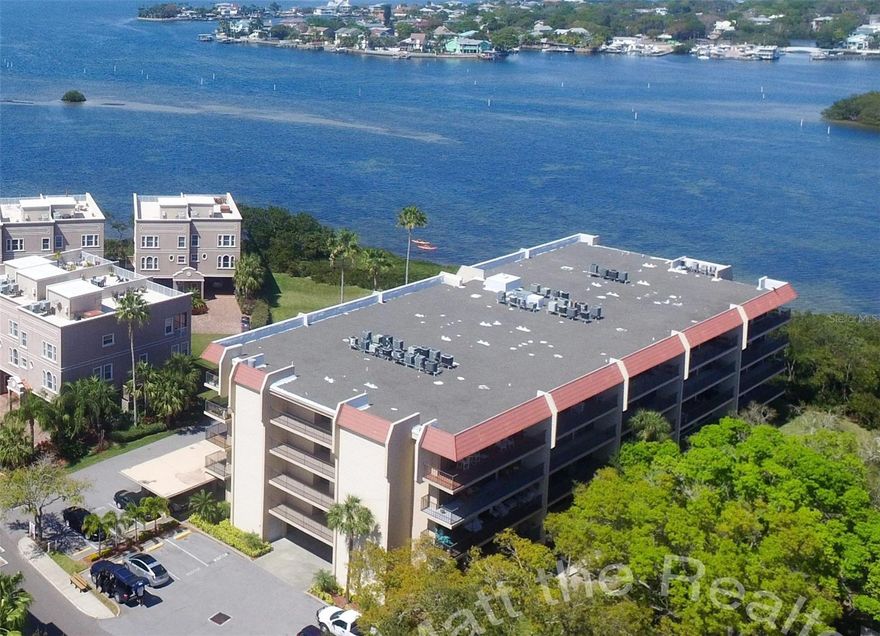 Dunedin waterview special! 36 foot balcony, 2BR, 2 bath split plan with nearly an entire wall of windows keeps it bright! Updated white cabinets/granite kitchen updated floors,  covered parking, security building and more! Small pet OK! On-site private beach and parks, waterfront clubhouse, rec building, heated pool +++