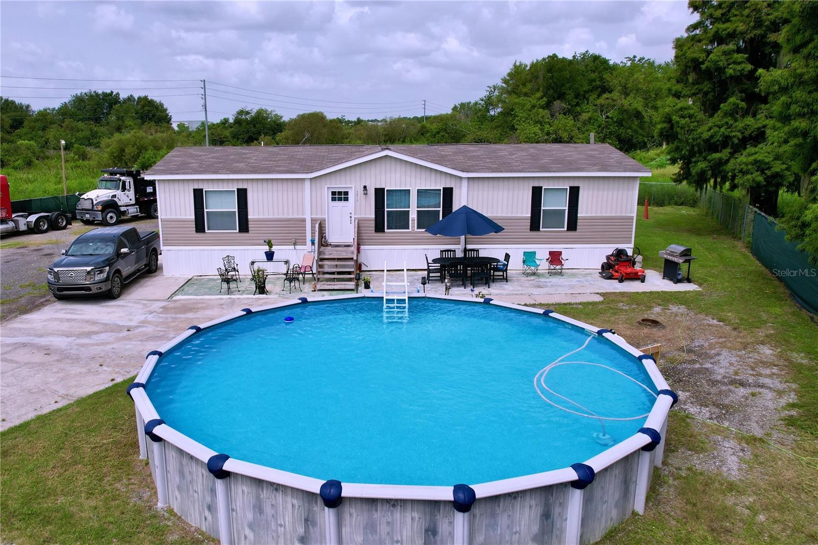 Discover this immaculate 2022 manufactured home, perfectly located near Polk Parkway and Bartow Road in Lakeland. Featuring 3 bedrooms and 2 bathrooms, this spacious residence sits on a fully fenced 1.08-acre lot, offering both privacy and endless possibilities. Whether you own trucks, trailers, or large vehicles, this property is a rare find with no HOA restrictions, giving you the freedom to park and use the land as you wish.
Enjoy sunny Florida days in the above-ground pool and take advantage of quick access to major roadways and all the amenities Lakeland has . Whether you're seeking peace and quiet, space to accommodate your lifestyle or a place to entertain, this home checks all the boxes. Don’t miss the chance to own a modern home with plenty of land, privacy, and no HOA limitations!