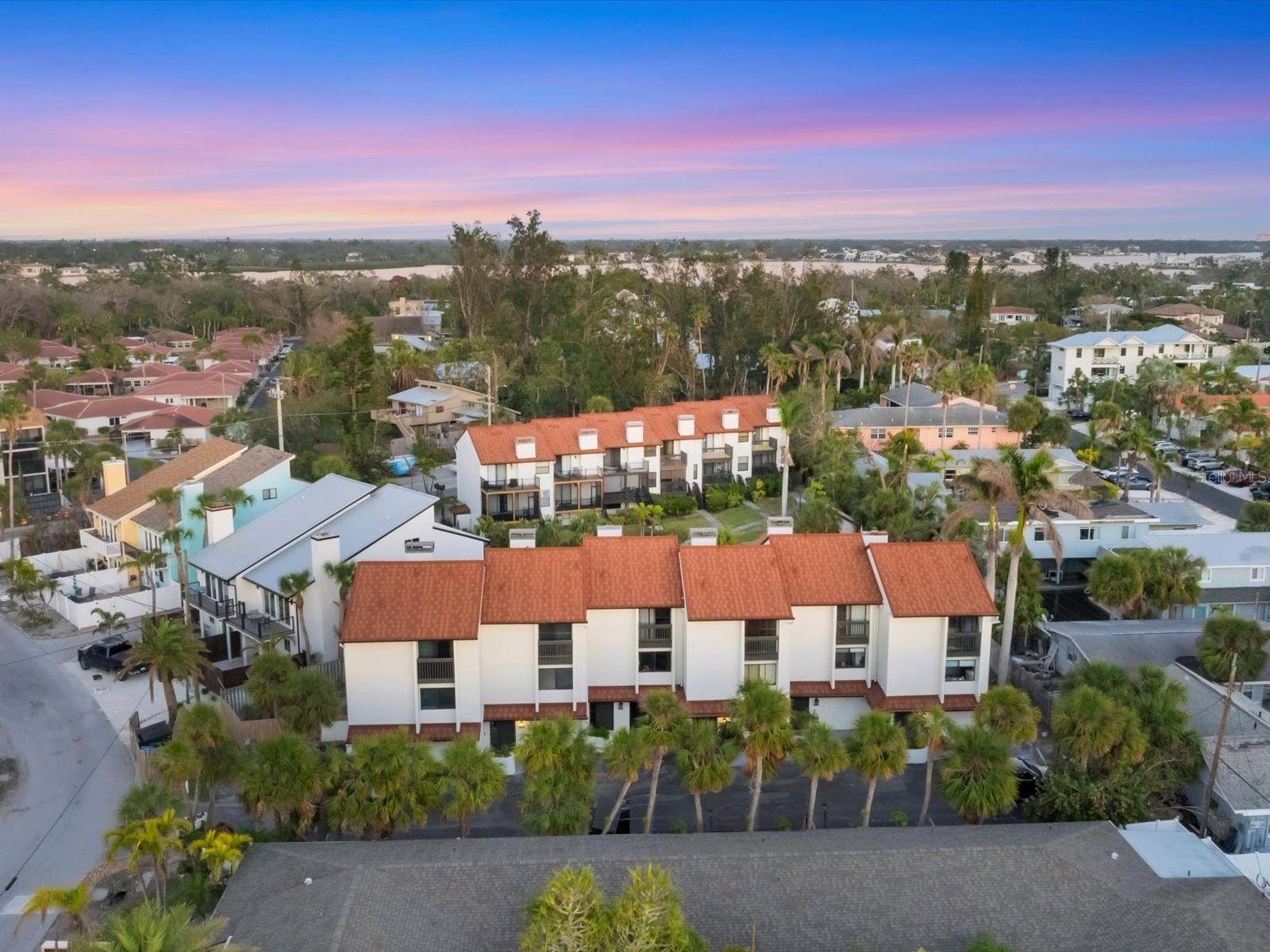 Just steps from the renowned Point of Rocks Beach, this beautifully appointed townhouse at 6790 Sarasea Circle captures the essence of coastal living with a balance of serenity and modern convenience. Set in an exclusive 12-unit complex, the residence offers direct access to Siesta Key’s world-famous beaches and village. Inside, the thoughtfully designed 1,446-square-foot interior features two bedrooms, two full baths and one half bath, creating a versatile retreat ideal for relaxed living and investment potential. The main living area is warm and inviting, with wood flooring, a cozy fireplace and a screened-in terrace overlooking the community pool. The bright, functional kitchen is designed for style and efficiency, featuring white cabinetry, generous counter space, tile flooring and a pass-through breakfast bar that seamlessly connects to the open dining area. A conveniently located powder room adds to the home's functionality, while a wooden staircase leads to the second level, where two well-appointed bedrooms share a Jack-and-Jill bath with private water closets and a shared shower. Each bedroom boasts spacious closets, a private balcony and abundant natural light, creating a tranquil retreat. Completing the home is an oversized one-car garage with direct access to lower-level bonus space. This recently updated space could be used in many different ways. With up to 12 rentals permitted per year, this property presents an exceptional opportunity to generate income while enjoying the best of island living. Just minutes from all Siesta Key has to offer and proximity to downtown, this coastal haven offers the ideal blend of relaxed island elegance and easy access to Sarasota’s vibrant cultural and recreational attractions.