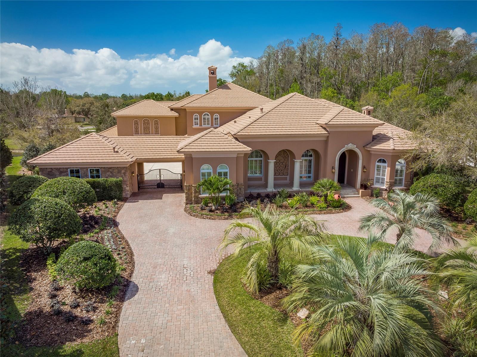 Private & Tranquil GATED community of The Preserve at Hawk's Landing! A world of entertainment in one grand estate! Fabulous theater seats 12, billiard room, bonus rooms and heated salt chlorinated pool/spa provide spaces for an array of fun! The SIX CAR GARAGE, accessed through a gated portico to the coach courtyard, accommodates auto collections and motor toys. HURRICANE IMPACT WINDOWS & DOORS. Hurricane shutters for the breakfast nook. Exterior body including all garage doors & front door painted April 2023! Whole house Generac GENERATOR installation in 2018 with 10 year warranty. New Trane 5 ton AC system with 19.5 Seer rating and a New Trane 4 ton AC system with an 18 seer rating installed 2022 . Control4 smart automation system. Located in a gated community on a .60 acre lot on a cul de sac, this home enjoys privacy. From the front porch enter double doors to a wall of windows overlooking the pool and nature. Formal living and dining rooms with wood floors. The island kitchen overlooks the breakfast room and the family room with encased wood beam ceiling detailing, wood floors, and wood-burning fireplace. The culinary arts inspired kitchen boasts Viking double ovens, microwave, and induction cooktop which is also plumbed for gas. Newer Viking cabinet-front refrigerator, counter style double beverage refrigerators and U-line wine refrigerator. Walk-in pantry & DUMBWAITER to second level. The first floor owner's suite has a wood-burning fireplace, sitting area, two walk-in closets, and exquisite bath with a walk-through shower for two with rain-shower, and dual sinks. TWO EXQUISTE OFFICES. The split floor plan has four bedrooms on the first floor and a guest bedroom suite on the second floor. Accommodates MULTI-GENERATIONAL needs! A huge first-floor exercise room or 6th bedroom could easily be modified for a first floor in-law suite. The second-floor bonus room has wood floors, wainscoting panels, a large wet bar with kegerator, beverage refrigerator, ample storage cabinets, and a balcony. A huge theater room has tiered seating, 115” theater screen and surround sound. Billiard room with wood floor and wood wainscoting panels. Newer water softener and 2023 pool pump. Security system with cameras. Screen doors added for 4 of 6 garages. The screened outdoor living space boasts a heated pool with fiber optic lighting, leased salt chlorinator, spillover spa, outdoor kitchen, plumbed for gas firepit, and large covered lanai. Minutes to beautiful beaches, YMCA, and Tampa International Airport. PLEASE TAKE THE VIDEO TOUR!!