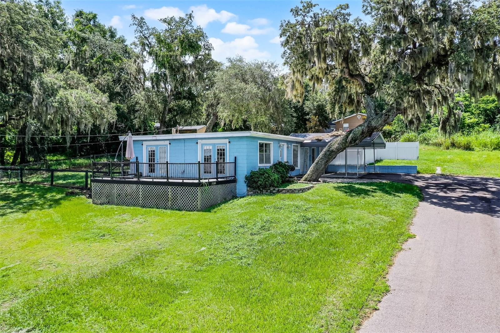 Lake View Gem Near Montverde Academy! Location, location, location! Nestled on a quiet, dead-end street with serene lake views of Lake Florence, this charming home offers the perfect blend of tranquility and convenience. Just minutes from the world-renowned Montverde Academy, this property is ideal for families or investors seeking a peaceful retreat with great potential. Step inside to find contemporary corrugated steel ceilings in the living room, giving the space a modern, artistic touch. The kitchen is equipped with premium Kitchenaid, Samsung, and Maytag appliances, ready for your culinary creations. A versatile office space can easily be converted into a 4th bedroom, offering flexibility to meet your needs. French doors open onto a peaceful deck, perfect for enjoying your morning coffee or winding down with sunset lake views. This is a unique opportunity to own a well-located property with character, comfort, and room to grow. No HOA!
