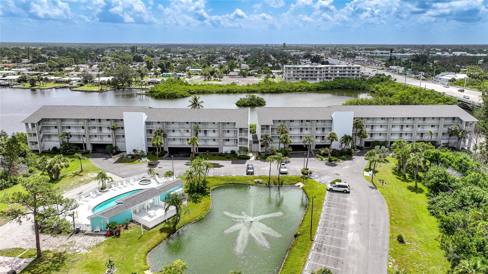 Welcome to this beautifully updated corner unit 2-bedroom, 2-bathroom condo just minutes from Englewood Beach, where peaceful views of Gottfried Creek and Lemon Bay greet you from the enclosed lanai. Thoughtfully redesigned, the open-concept layout blends the kitchen and dining area into one seamless space perfect for entertaining. The spacious kitchen, featuring granite countertops, an oversized island, and contemporary cabinetry. The glass enclosed lanai is perfect for enjoying your morning coffee or evening glass of wine year-round, complete with pocket sliding glass doors, screens, and shades. Hurricane impact doors and windows provide peace of mind and energy efficiency. Enjoy added convenience with under-building parking, elevator access, guest parking, and community amenities such as a private boat ramp with available slip, pool, tennis courts, and BBQ area. A new roof was completed in 2023, and the condo is part of a well-managed complex close to beaches, shopping, dining, and entertainment.