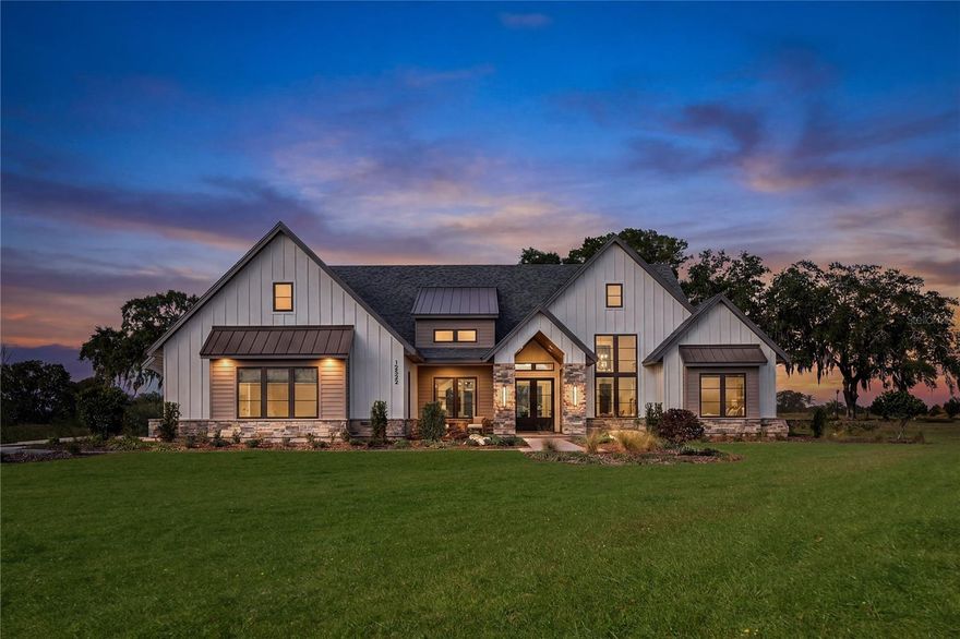 Fully furnished and professionally decorated — this luxury Modern Farmhouse pool home is located in the exclusive gated community of Flint Rock Agrihood.

Built by AR Homes, the Sienna offers 3,824 square feet of thoughtfully designed living space on a private one-acre homesite backing to common area, complete with a three-car side-entry garage and timeless curb appeal.

A welcoming vaulted front porch with tongue-and-groove wood ceilings and stone accents sets the tone for the craftsmanship inside. The dramatic 16-foot vaulted great room with exposed wood beams and a wall of 10-foot sliding glass doors creates a bright, open layout with seamless indoor-outdoor living.

The chef’s kitchen is anchored by a nearly 10-foot island and features GE Monogram appliances, double ovens, a drawer microwave, statement wood vent hood, and a spacious walk-in pantry with custom cabinetry and secondary refrigerator. A 48” fireplace with honed leathered granite surround adds warmth and architectural presence to the main living space.

The private owner’s suite occupies its own wing and showcases a spa-inspired bath with dual vanities, freestanding tub, walk-in shower, and an oversized closet with direct access to the utility room.

Transition effortlessly outdoors through the floor-to-ceiling sliding glass wall opening to a spacious lanai and cabana. Travertine pavers lead to a custom-designed heated pool featuring an infinity-edge spa, sunshelf, and clear panel screen enclosure. A fully equipped summer kitchen completes this private outdoor retreat.

Designed for modern living, the home includes four ensuite bedrooms, five full baths, a large bonus room, a dedicated home office with glass wall detail, and single-story ease of living.

Enjoy the unique Flint Rock Agrihood lifestyle, where gated privacy meets open green space, scenic views, and a connection to nature.

Opportunities to own a professionally designed AR Homes model are rare — schedule your private tour today.