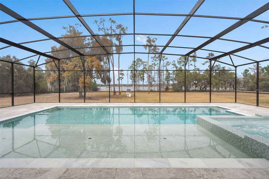 Private 5-acre lakefront estate in the gated community of Lake Hendon Reserve with over 160 feet of frontage on a spring-fed lake. Designed to maximize water views and outdoor living, the property features a newly constructed 2025 saltwater pool with 25-foot sun shelf, 16-person spa, marble pool deck, and a renovated 2025 private dock providing direct access for boating and fishing.

Located minutes from Lake Nona’s Medical City with convenient access to Narcoossee Road, USTA National Campus, SR 417, and Orlando International Airport.

Double glass entry doors open to interiors with double crown molding, 5-inch baseboards, and lake views from multiple living areas. The kitchen includes quartz countertops, oversized island with seating for six, custom cabinetry, double ovens, gas cooktop with pot filler, additional prep sink, added electrical outlets, and stainless steel appliances overlooking the water.

The family room with gas fireplace opens to a covered rear porch pre-plumbed and vented for a future outdoor kitchen. The primary suite is privately positioned in the east wing with lake views and direct porch access. The primary bath includes dual vanities, walk-in closet, and oversized shower with dual shower-heads.

Additional spaces include a dedicated home office, upstairs loft, downstairs guest bedroom, two additional upstairs bedrooms, and a 700-square-foot bonus/flex room suitable for media, game room, or additional bedroom.

Four-car garage with extended depth, insulated and climate controlled with heating and air conditioning, plus motorized garage screens. Dual HVAC systems replaced in 2021. New 2025 whole-home water filtration system, including reverse osmosis filter at the kitchen sink. Low-E windows and radiant heat barrier.



Video tour available.