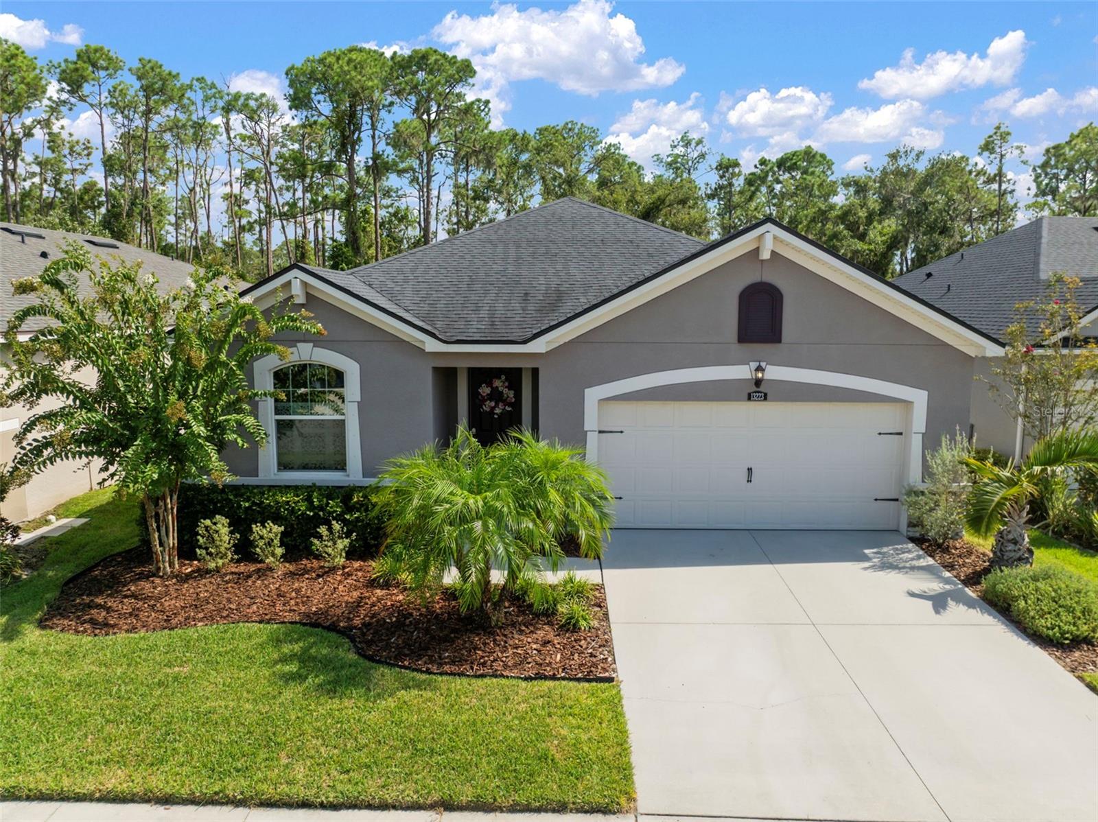 Welcome home to this stunning and nearly new home with upgrades throughout and that is walking distance to a scenic nature trail! As you enter this home you will visibly find through the rear sliders the most serene mature Florida landscape with tree lined views as far as the eye can see. A family of bald eagles frequent a tree very near the backyard that is visible from the back patio! Inside the home, you will enjoy a den near the entrance with glass paned French doors, followed by an open floor-plan connecting the kitchen, dining, and living rooms all featuring upgraded wood-look tile. The kitchen boasts granite countertops, ample storage, soft-close cabinetry, all stainless steel appliances, and an upgraded refrigerator! The 8 foot doors and raised ceilings throughout feature a regal experience as you move around the home, enhancing the home's size and feel. You will be dazzled by the upgraded lighting in several areas of the home as well as the upgraded primary suite boasting quartz countertops and a garden tub/ shower combo! Most recent upgrades include a screened enclosure for the rear patio as well as a 14-50 garage outlet for your electric vehicle. The peace and serenity of this home's unique location and position, paired with the abundant resources of the neighborhood including gorgeous amenities, schools and an elevated learning preschool within the neighborhood itself offer your family everything you need for peace, fun, and enrichment! This home will not last long, come see it today!