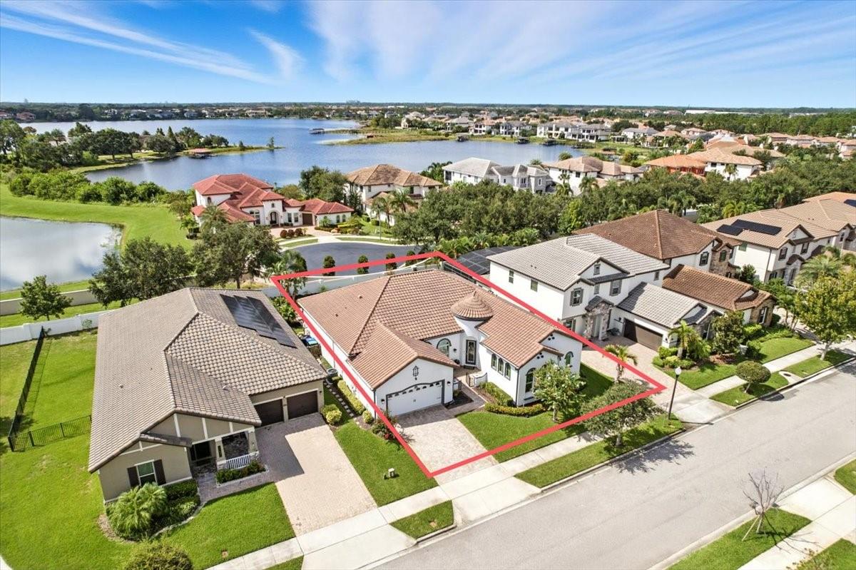 Welcome to Enclave at Windermere Landing! This original-owner home, built in 2015 by Meritage Homes, offers nearly 2,800 sq. ft. of one-level living with soaring 12-foot ceilings that create an airy, grand atmosphere throughout. Featuring 3 bedrooms plus a den/office (easily convertible to a 4th bedroom), 2.5 baths, and a 3-car tandem garage, this home is truly one of a kind—the only Arcata floorplan built in the neighborhood. The Mediterranean-style exterior boasts a tile roof, freshly repainted in 2023, and a charming courtyard entry that sets the tone. Inside, a rotunda foyer opens to formal dining and an expansive great room with a dramatic floor-to-ceiling stone fireplace, recessed TV niche, and ventless multi-color electric fireplace. South-facing transom windows flood the space with natural light, while sliding doors lead to the sparkling heated saltwater pool and screened lanai with motorized retractable awning. The chef’s kitchen features quartz counters, a massive island, wall oven and microwave, near-ceiling cabinetry, butler’s pantry, oversized walk-in pantry, and 2022 Samsung refrigerator. The primary suite overlooks the pool and includes a luxurious bath with soaking tub, dual vanities, and a grand walk-in closet with 12-ft ceilings. Two additional bedrooms share a Jack-and-Jill bath, each with their own vanity, plus a walk-in linen closet. The den offers flexibility for a 4th bedroom or en-suite conversion. Additional features include premium new carpet in bedrooms, Culligan water softener, spray-foam insulated attic with storage, plantation shutters, ceiling fans, and a 16x32 heated saltwater pool. Located within walking distance to Sunset Park Elementary, minutes to Windermere High School, the Butler Chain of Lakes, and just 15 minutes to Disney, this home combines convenience, luxury, and timeless style. Rarely does a one-story pool home with this level of design and detail become available in Windermere—don’t miss it!