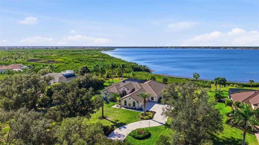 THE MYAKKA ESTATE RIVERFRONT JEWEL-Set on nearly two acres of breathtaking waterfront scenery, this Arthur Rutenberg custom residence has been beautifully reimagined to reflect today’s most sought-after trends in luxury coastal design. With an impressive 220 feet along the Myakka River, the home blends romantic riverfront elegance with a refined indoor/outdoor lifestyle that defines Florida living at its best. From the moment you step inside, the home unfolds with modern sophistication. Cathedral ceilings trimmed with crisp crown molding elevate the living areas, while expansive floor-to-ceiling windows showcase ever-changing views of the heated pool, lush greenery, and shimmering river. The interiors highlight a curated mix of high-end finishes—wide-plank laminate floors with the look of natural wood, polished ceramic tile, designer lighting, and a neutral color palette accented with coastal textures for a warm, airy ambiance. The open kitchen caters both to casual living and gourmet cooking. Trend-forward elements include sleek stainless steel appliances, a stylish cooktop island with waterfall-style edge, contemporary cabinetry, subtle under-cabinet lighting and a spacious breakfast bar ideal for entertaining. All 4 bedrooms offer their own private retreat, offering an ensuite bath, generous closets, and updated finishes inspired by spa-level serenity—floating vanities, modern fixtures, and soothing tile selections. Multiple sets of sliding glass doors from the formal living room, family room, and primary suite invite you to the expansive pool travertine terrace where everyday moments feel like a vacation. Lounge by the very large heated pool and spa, enjoy a refreshing breeze beside the peaceful waterfall feature, or host unforgettable gatherings around the outdoor kitchen and grill. Not to mention fabulous Florida scenic sunsets. Additional highlights include a three-car plus garage,two zoned A/C units and thoughtful upgrades throughout. The social lifestyle is unmatched in the gated Riverwood Golf and Country Club community, offering golf, tennis, fitness, an active clubhouse, on-site dining, and numerous opportunities to connect with neighbors and friends. Riverwood itself is a secure, resort-style haven where residents enjoy scenic walking and biking trails, tennis and pickleball courts, a resort-style pool and lap pool, hot tub, well-equipped fitness center, and a vibrant Activity Center with classes, clubs, and events. As an Audubon Green Community, it offers a naturally picturesque setting filled with native Florida wildlife. Residents also appreciate the R.O.M.P. Dog Park and optional membership at the Championship Golf Course, rated number 1 in Florida by Golf Digest. Special added BONUS this Estate offers a coveted TRANSFERRABLE RIVERWOOD BEACH CLUB MEMBERSHIP on MANASOTA KEY. Perfectly positioned between Sarasota and Fort Myers along Florida’s Gulf Coast, Riverwood places you close to beaches, boating, cultural venues, restaurants, and shopping. Contact your agent today to explore this extraordinary residence and experience the unparalleled Riverwood lifestyle firsthand.