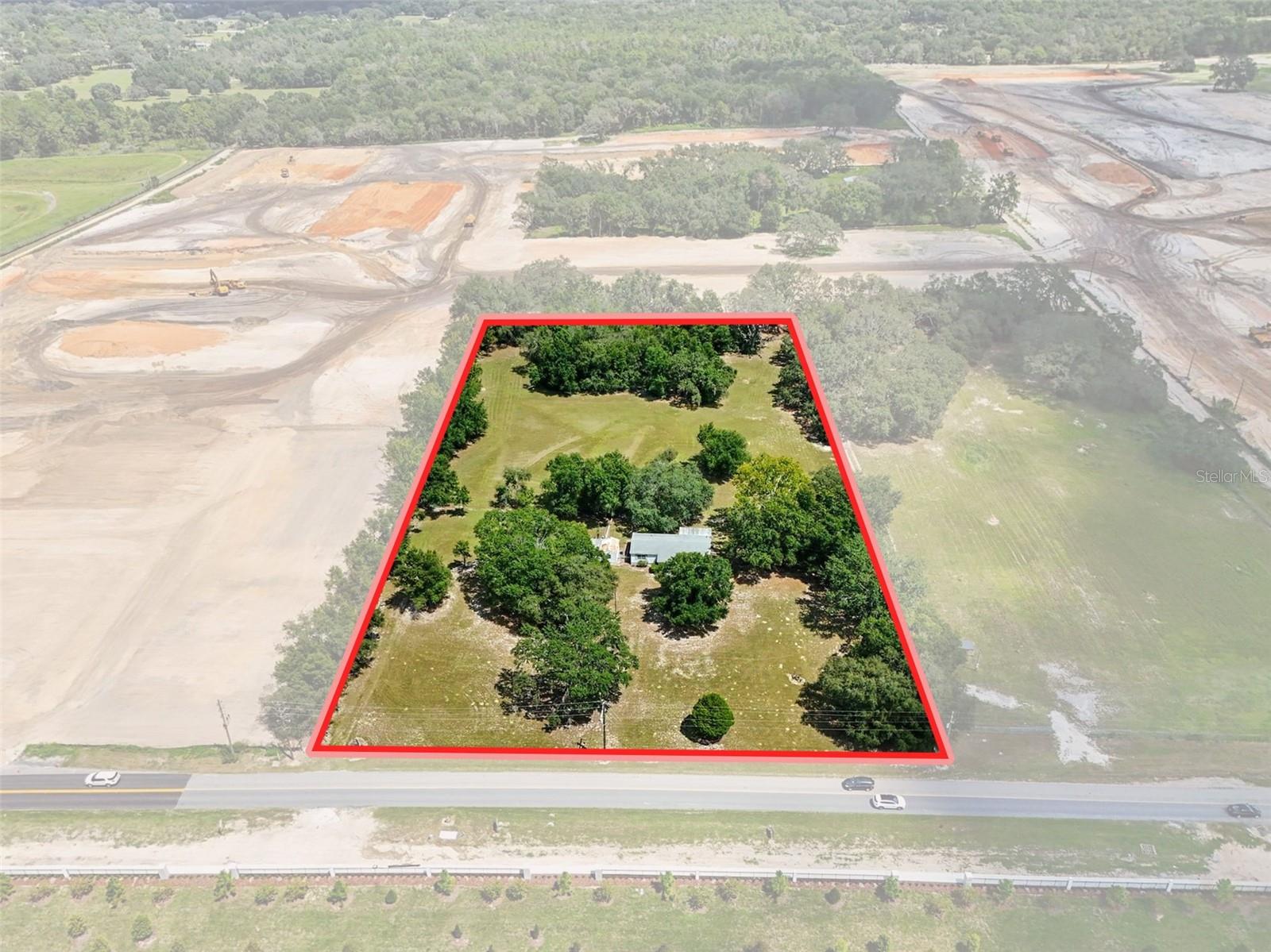 Just shy of 5 acres, this 4.8-acre property in Lady Lake offers a serene setting beneath beautiful old oak trees and includes a 3-bedroom, 2-bath mobile home, a detached one-car carport, and a storage shed/workshop with laundry area, along with a private well and septic. While the home is livable, the true value lies in the land itself—surrounded by properties annexed into the City of Lady Lake, yet remaining in unincorporated Lake County, providing both privacy and future opportunities. With development happening all around, this property is ideal for those seeking their own private homestead or for buyers looking to invest in nearly 5 acres in a rapidly growing area.