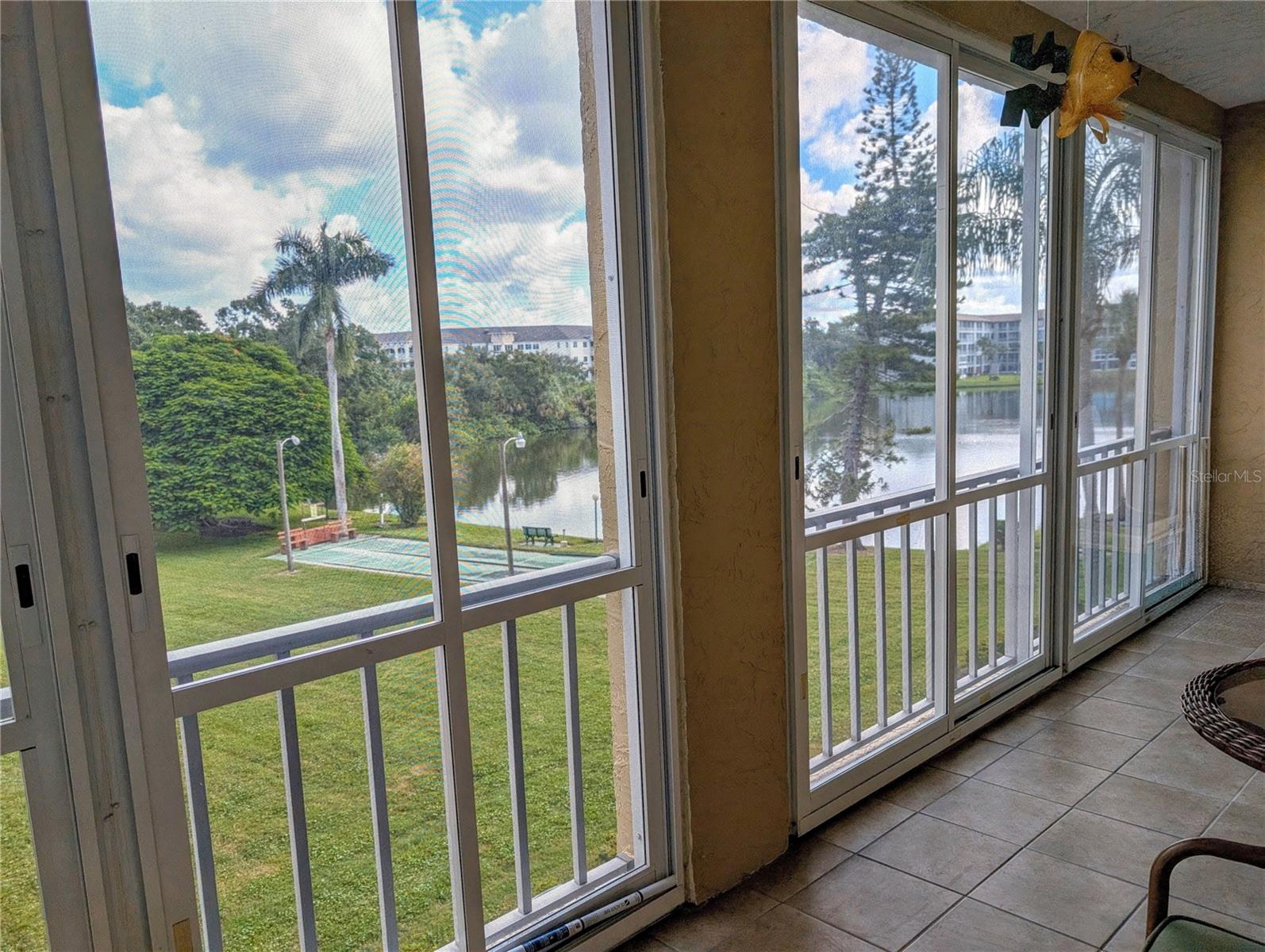 Delightful, spacious and full of upgrades: a pretty 2BR/2BA Turnkey Furnished condo that's truly 'move-in-now' ready on lake. Interior features ~ amazing ceramic tile plank flooring thru all rooms except guest room. Sleek kitchen with stainless appliances & plenty of updated cabinets & counter space. Replaced HVAC '23, H2O '24. Comfortable master bedroom w/ensuite bath. Both sets of sliding doors onto the (enclosed) lanai are beauties: heavy duty, noise/temp proofing. Stack Washer/Dryer is a benefit (no need to use community ones). Charming setting & views from lanai (beautiful tile flooring, sliding floor-to-ceiling windows to enjoy the views thruout the seasons. Active 55+ community offers heated pool/spa, clubhouse, plus picnic tables, gas grill and a fishing pier all in a very pretty setting. No pets. Centrally located near shopping, restaurants, golf courses, multiple hospitals & healthcare facilities; head east to UTC's shopping, dining & entertainment or west 10-15 minutes to sandy Gulf beaches on Anna Maria Island. Interested? Come see...