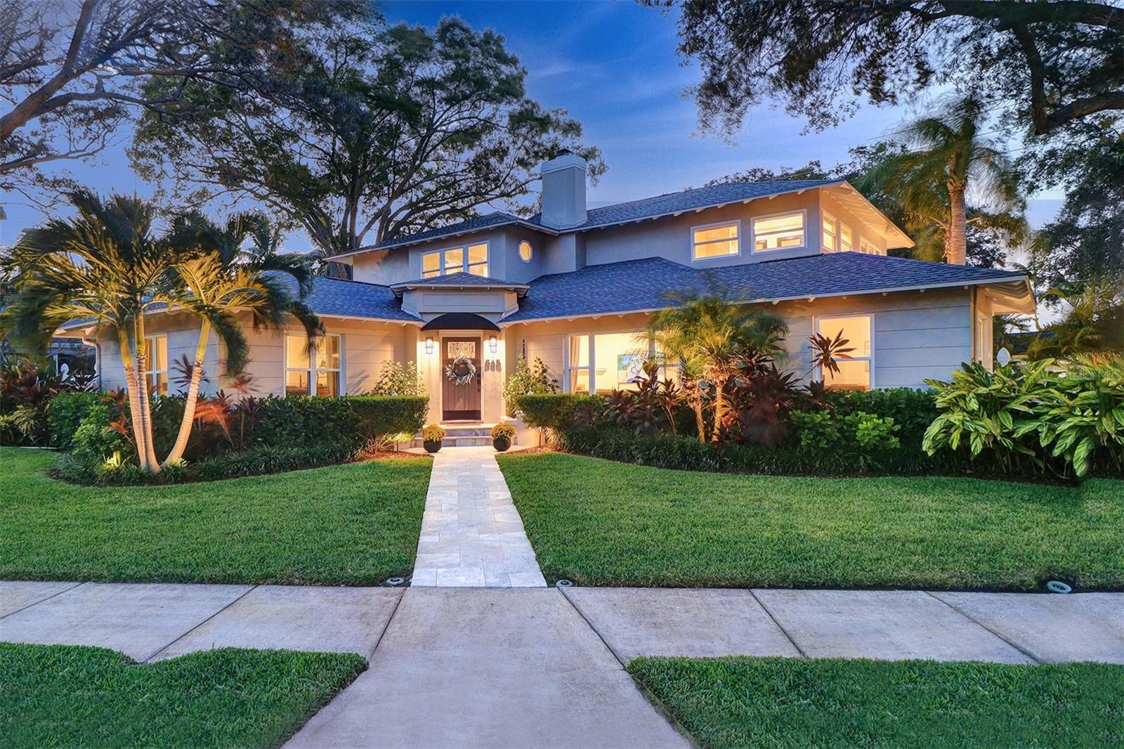 Stunning water view home situated in the heart of Historic Old Northeast! Located within steps to Tampa Bay waterfront, Vinoy Golf Course and North Shore Parks, this home offers a perfect blend of contemporary style and classic elegance with a flexible floor plan that boasts two en-suite bedrooms on the main floor, perfect for multi-generational living. Situated on an oversized corner lot you’ll notice this home has tremendous curb appeal, highlighted by twin majestic oak trees that frame the house perfectly. Enter through the Arts & Crafts mission style front door into a warm expansive home that features 5 bedrooms, 5 baths and over 3,400 SF of living space that’s been beautifully updated with custom high end finishes including a newer roof, hurricane impact widows & doors and oak wood floors throughout. The homes open concept gourmet kitchen features a large island with plenty of seating, a Viking “gas” range, a large farmhouse sink, and a built-in wine fridge. Open the French doors off of the kitchen and dining room to take in the breezes from the nearby waterfront and relax and unwind by the pool. The sun room located off the great room has custom built -ins and offers plenty of natural sunlight. A bonus room near the kitchen makes for a great home office or cozy den.
Located off the kitchen is an attached two car garage which makes bringing in groceries a breeze.The upstairs master bedroom features a large en-suite bath with dual sinks, soaking tub, separate shower, and a large walk-in closet. Also on the 2nd floor are two additional large bedrooms and a nicely equipped laundry room. The large private backyard offers plenty of entertainment and features a luxurious heated saltwater pool & spa and terrace that accommodates plenty of outdoor seating as well as a side patio with large outdoor kitchen. There is also a “hidden away” tree fort & play ground surrounded by lush mature landscaping. Less than 20 steps to paddle boarding, fishing, and parks this home has something for everyone and is located only a short walk from vibrant downtown St Petersburg where you can enjoy fine dining, shopping boutiques, visit museums and art galleries.
