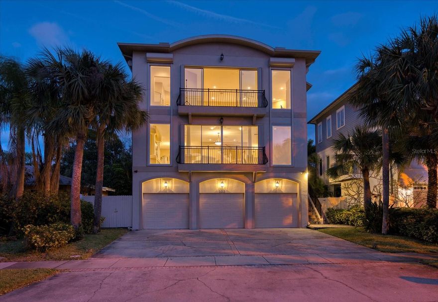 Breathtaking views of sunsets and the turquoise waters of the Gulf await from the expansive west side of this custom designed 6 bedroom/5 bath home located just steps from Carlouel Yacht Club! A spectacular great room offers a panoramic wall of windows and sliding doors, a wet bar with wine cooler, and media cabinets for the television shelf flanked by decorative columns. An open dining area adjoins the island kitchen featuring abundant storage, solid surface counters, and a built-in desk. There are three bedrooms, two baths, and a laundry room on this level. The upper-level primary bedroom suite provides another wall of floor-to-ceiling windows with Gulf views and a luxury bath with dual sink vanity, whirlpool tub, glass front shower, and walk-in custom closet. On this level, there is a large second-bedroom suite with private bath and walk-in closet, a sixth bedroom used currently as an office, and a loft living area. Other features include a ground-level entertainment space with sliding doors opening to a screened backyard lanai, neutral ceramic tile floors, an elevator, and three car garage. Walk to the deeded beach access to wade in the Gulf or watch the sunset. Only minutes to Clearwater Beach restaurants and attractions!