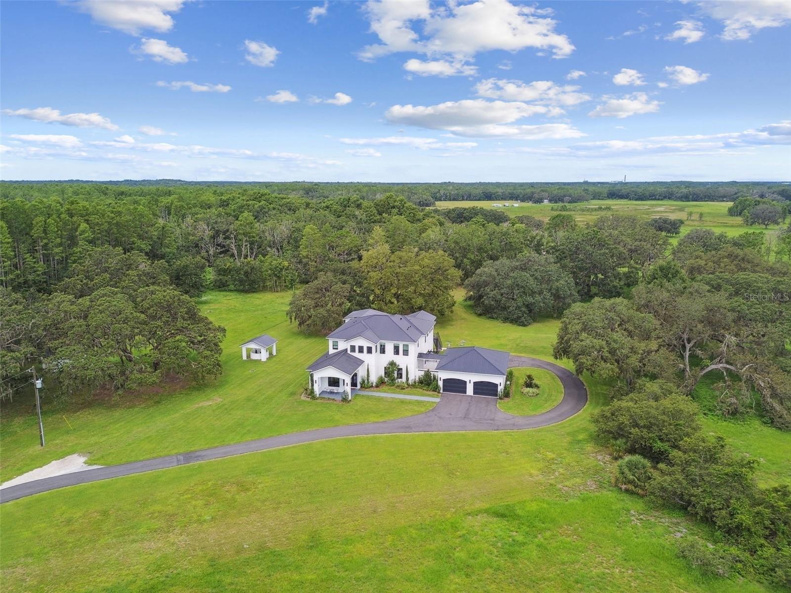 Welcome to your private estate in the country, just minutes to everything you need! This sumptuous and exquisite luxury home built just 2 years ago, sits on almost 25 acres! With 5-bedrooms, 5.5 baths, the 4571 sq ft feels both modern and yet cozy at the same time. NO HOA! Agricultural zoning (AC) which makes it INCREDIBLY valuable due to the ability to subdivide and affords a variety of permitted uses such as a wedding venue, horse stables, farming, and more. This property can be green belted saving thousands on taxes! This zoning is extremely difficult to find and the possibilities are endless and income producing as well.
As you walk through the covered front porch and through the double door entry, you will notice the harlequin chequerboard marble flooring. To your left you will find an office with views of the front fields and the pond (what a way to spend your workday!) and next to the office is one of the 5 ensuite bedrooms with a walk-in closet. Continuing to the kitchen, there is large Music Room on one side which could also be a library, a 2nd office, a play room, or a den. Then we have the WOW Gourmet Kitchen! Featuring quartz countertops, a La Cornue handcrafted French gas range with 6 burners, an Euclid hood that reaches the ceiling, a Thermador paneled refrigerator, and paneled dishwasher, custom cabinetry with slide-out, soft-close drawers, and a breakfast bar complete this stunning kitchen. There is also a Butler’s Pantry which provides more counter space with quartz countertops, additional cabinet space, and a second refrigerator. There is both a living room on one side of the kitchen and a great room or TV room on the other side with the dining space in the middle, creating a seamless flow for entertaining, allowing you to enjoy panoramic views of the lush landscape from every window, enhancing the tranquility and beauty of this unique property. This open-concept living and dining areas invite seamless indoor-outdoor living through the 3 sets of sliding glass doors.
The rear facing staircase leads to the second floor where you will find a loft space that overlooks the dining room below. In each corner of the 2nd floor there is an ensuite bedroom. Three additional bedrooms with walk-in closets and private bathrooms (4 ensuite bedrooms plus the Primary for a total of 5 ensuite bedrooms), all with views of the property and one of which has sliding glass doors and a private patio. Then the primary bedroom has its own sliding glass door that leads to an outdoor patio, a huge walk in closet and two entries into the primary bathroom which has double sinks, a soaking tub, and an enormous walk-in shower with two shower heads and a rainfall shower head. The 4 car garage is connected to the house with a covered walkway complete with a stunning waterfall designer touch and there is an outdoor shower! The walkway leads in the mudroom with a sink and lockers, plus a workspace. The 5-acre pond serves as your retention pond and keeps the rest of 19+ acres high and dry. NO FLOOD INSURANCE REQUIRED!! This exquisite residence combines elegance, functionality, and unrivaled natural beauty, making it the perfect sanctuary for those seeking luxury and tranquility in harmony with nature.
(PLEASE NOTE - DO NOT TAKE KENT GROVE DR FROM ROUTE 52!! STAY ON 52 TO 41 NORTH AND TURN ON GREENFIELD)