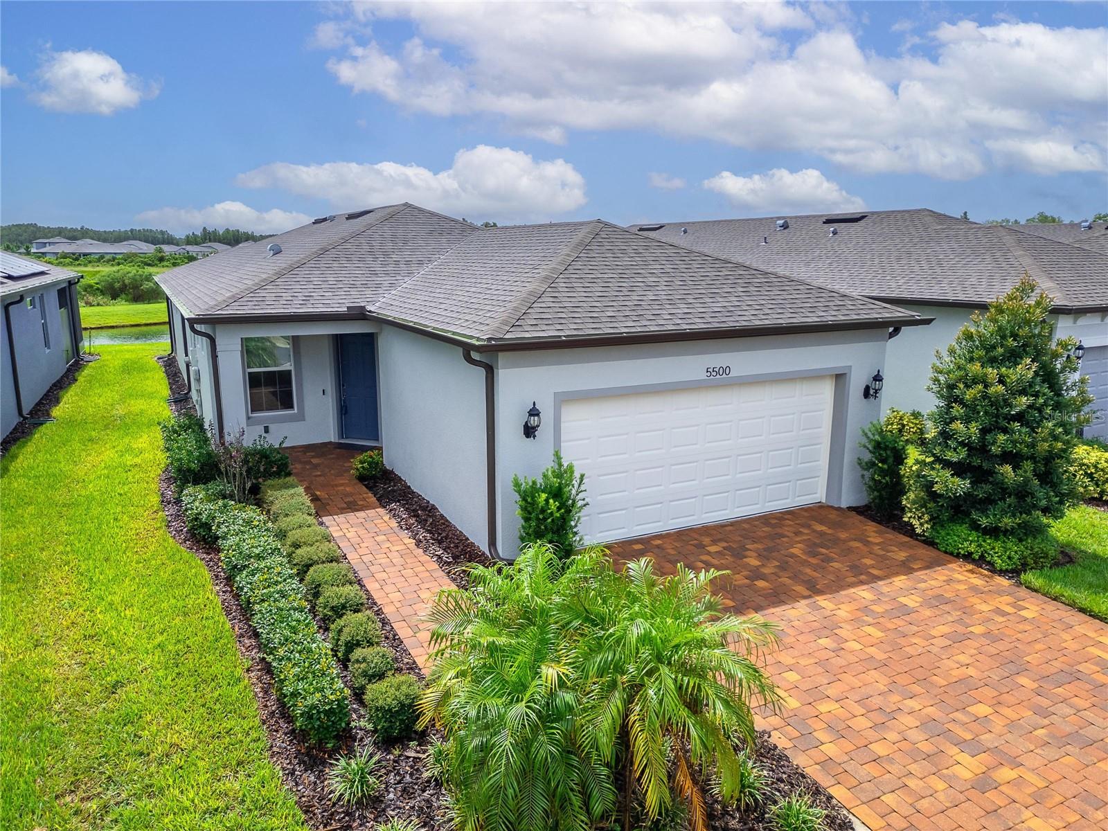 One or more photo(s) has been virtually staged. WATER VIEW! - Enjoy unwinding on your spacious screen enclosed lanai overlooking a tranquil pond. - There you will find a gas line stub, so you can use a natural gas grill. Life is good in this 55+ vibrant Del Webb Bexley community, where a full-time activities director ensures there’s always something fun to do. Step inside this 3 yr new home where just off the foyer you will discover a flex space—ideal for crafting, gaming or working at your desk. The open floor plan creates a roomy feel, perfect for entertaining guests while you cook in your modern kitchen, complete with Whirlpool Stainless Steel appliances, Granite countertops, a chevron tile backsplash, pendant lighting over the breakfast bar and elegant dark cabinetry. Coastal Blue accent walls add a refreshing touch throughout the home. At the front of the home, you’ll find a guest bedroom with a walk-in closet and a full bathroom, while the primary ensuite bedroom is tucked away at the back for maximum privacy. The primary bathroom boasts dual sinks, granite countertops, linen closet and a glass shower with bench and soap niche. Both bedrooms are carpeted, while the rest of the home features beautiful, upgraded large-format tile flooring. Storage is plentiful with a coat closet, linen closet and an extra-large primary suite walk-in closet. The inside laundry room includes a Whirlpool washer and dryer for your convenience. The epoxy finished two car garage has been extended by four feet, providing space for an extra-long SUV or additional storage. Your monthly HOA fee includes the use and maintenance of state-of-the-art amenities, landscaping within the common areas inside of the gates and maintenance of the landscape on your home site. In addition your monthly fee includes a broad internet and cable TV package. In this gated community the clubhouse features a fitness center, ball room, multi-purpose rooms, clubs, planned activities, a bistro and more. Outdoors you will enjoy bocce ball, pickle ball, tennis, a resort style zero entry heated pool, additional walking resistance pool, spa, community garden and even a dog park. Feel free to jump on your golf cart and drive to the Meridian Clubhouse where you will meet up with your new friends and neighbors!