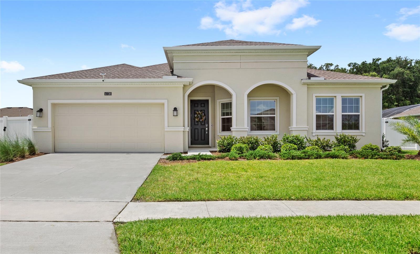 Welcome to 6138 Claystone Way, a stunning 2023-built Bonita II model located in the highly sought-after gated community of Stoneybrook Hills in Mount Dora. Situated on a rare half-acre homesite, this meticulously maintained home offers privacy with a fully fenced backyard. The yard also features upgraded landscape and yard lighting. Inside, the spacious and open concept layout features 3 bedrooms, 3 bathrooms, and a flex space that is perfect for a home office or playroom. The kitchen boasts white cabinetry, quartz countertops, stainless steel appliances, a large island, custom pull-outs in the cabinets, a touch-sensor faucet, and a large pantry. Motorized shades on the sliding glass door lead out to an expansive outdoor living area that includes a fully screened-in lanai under roof, a 10’x40’ open poured patio, and an additional 10’x20’ patio, all overlooking a beautiful and quiet tree-lined view. The private primary suite is tucked at the back of the home and filled with natural light, featuring an en-suite bath with oversized vanities, a soaking tub, enclosed shower, and a large walk-in closet. The two additional guest bedrooms are spacious, and feature a large guest bathroom situated in between. Additional upgrades include a whole-home water filtration and softener system, upgraded bathroom mirrors, and a three-car tandem garage under HVAC with two 4’x8’ overhead storage racks, added sink, and built-in shelving. Stoneybrook Hills offers resort-style amenities including a 24-hour manned security gate, Olympic-size pool, splash pad, fitness center, clubhouse, playgrounds, basketball and tennis courts, baseball fields, and scenic walking trails. Ideally located with easy access to US-441 and the 429 connector, you're just minutes from historic downtown Mount Dora and a short drive to Orlando, Disney, and the airport. This is your opportunity to own a move-in ready, fully upgraded home in Mount Dora. Call today to schedule a private tour.