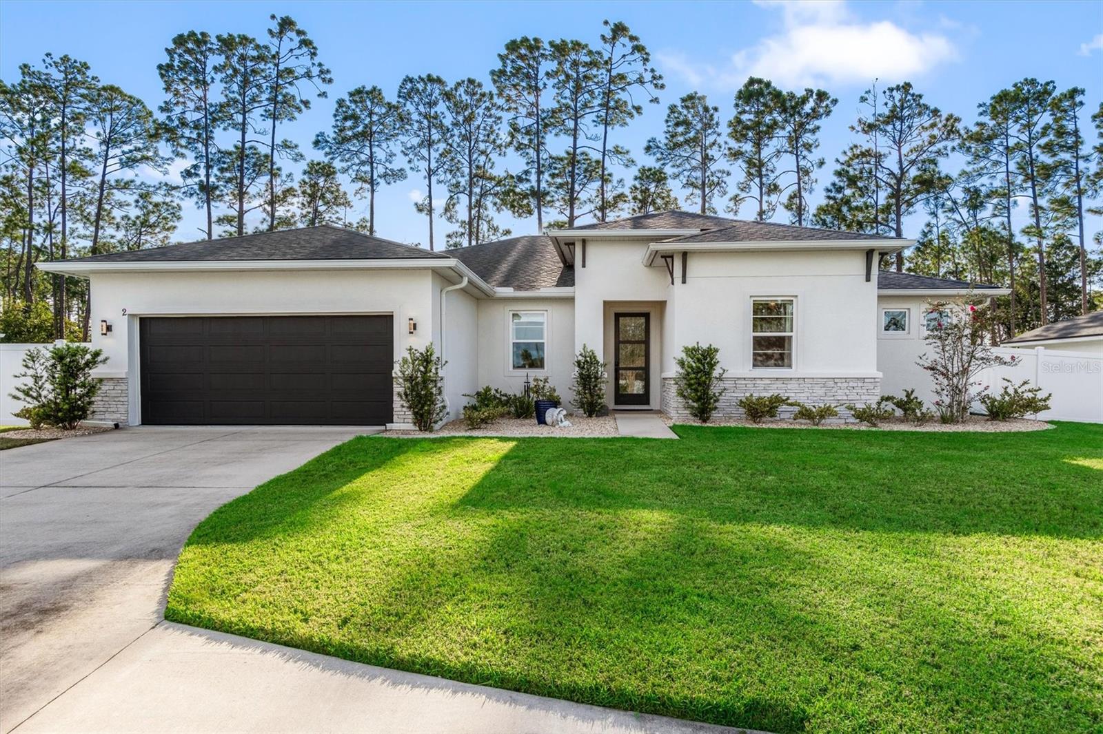 ***SHOWS LIKE A MODEL AND OFFERS BIG ENERGY SAVINGS***Welcome to 2 Westbury Place, a beautifully crafted home. Built in 2022, this 4-bedroom, 3-bath residence offers over 2,300 square feet of thoughtfully designed living space. The open-concept layout is ideal for both entertaining and everyday comfort, featuring a spacious living and dining area that flows seamlessly into the kitchen. Here you’ll find quartz countertops, a large island, updated appliances, and a custom pantry system convenience and organization. Wood-look tile, recessed LED lighting, upgraded lighting fixtures and energy-efficient design elements bring both modern appeal and long-term value. You'll also find sleek and modern hardware updates throughout.The primary suite serves as a private retreat with decorative custom board and batten wall and barn door to bathroom. Enjoy a spa-inspired primary bath with a generous walk-in closet complete with closet system. Three additional bedrooms offer flexibility for family and guests. Additional room could be used as sitting room or home office. Smart home technology, OWNED solar panels, and spray foam attic insulation provide comfort with excellent efficiency. Outdoors a fully fenced yard includes a covered screened lanai with extended patio overlooks the spacious lot, perfect for relaxing or entertaining. Combining modern upgrades, sustainable living, and a prime Palm Coast location, this home truly has it all.